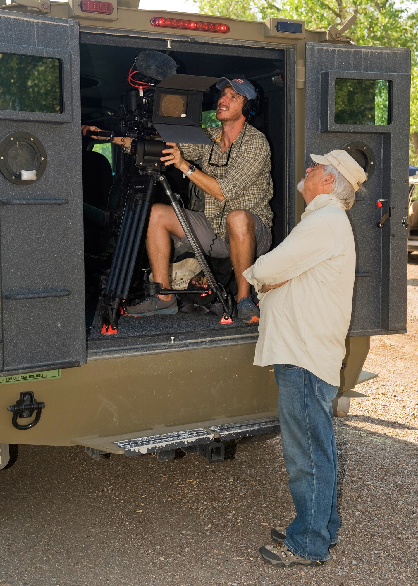 David Tinsley, left, and his father, Albert, both of Cubic Video, adjust camera settings as they record the sound of a Payload Transporter's engine running for a training video. (U.S. Air Force photo/Beau Wade)