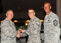 Col. Scott Rizer 319th Air Base Wing vice commander, presents Airman 1st Class Charles Coushaine, IV, Force Support Squadron, with a Diamond Sharp Award July 19, 2012, on Grand Forks Air Force Base, N.D., accompanied by 319th ABW Command Chief Master Sgt. David Carlson.  The Diamond Sharp Award is given to Airmen who epitomize service before self and strive for excellence at work and off duty.  (U.S. Air Force photo by Airman 1st Class Xavier Navarro)  