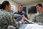 Staff Sgt. Easter Jackson, clinical instructor, explains the functions of a transport ventilator to Navy Petty Officer 2nd Class Justin Speight, an Interservice Respiratory Therapy Program student, as Maj. Thomas Zanders, the program's medical director, looks on in the Pulmonary Department at San Antonio Military Medical Center, May 23, 2012. U.S. Army photo by Elaine Sanchez. 