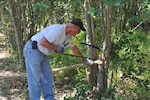 Col. Scott Kimmell, U.S. Army Environmental Command commander, clears non-native, invasive plant species at John James Park at a recent community cleanup event. U.S. Army Environmental Command teamed up with the San Antonio Parks and Recreation Department and other member organizations at Joint Base San Antonio to mulch trees and thin out undesirable plant and tree species from the park.(U.S. Army photo/Barry Napp)