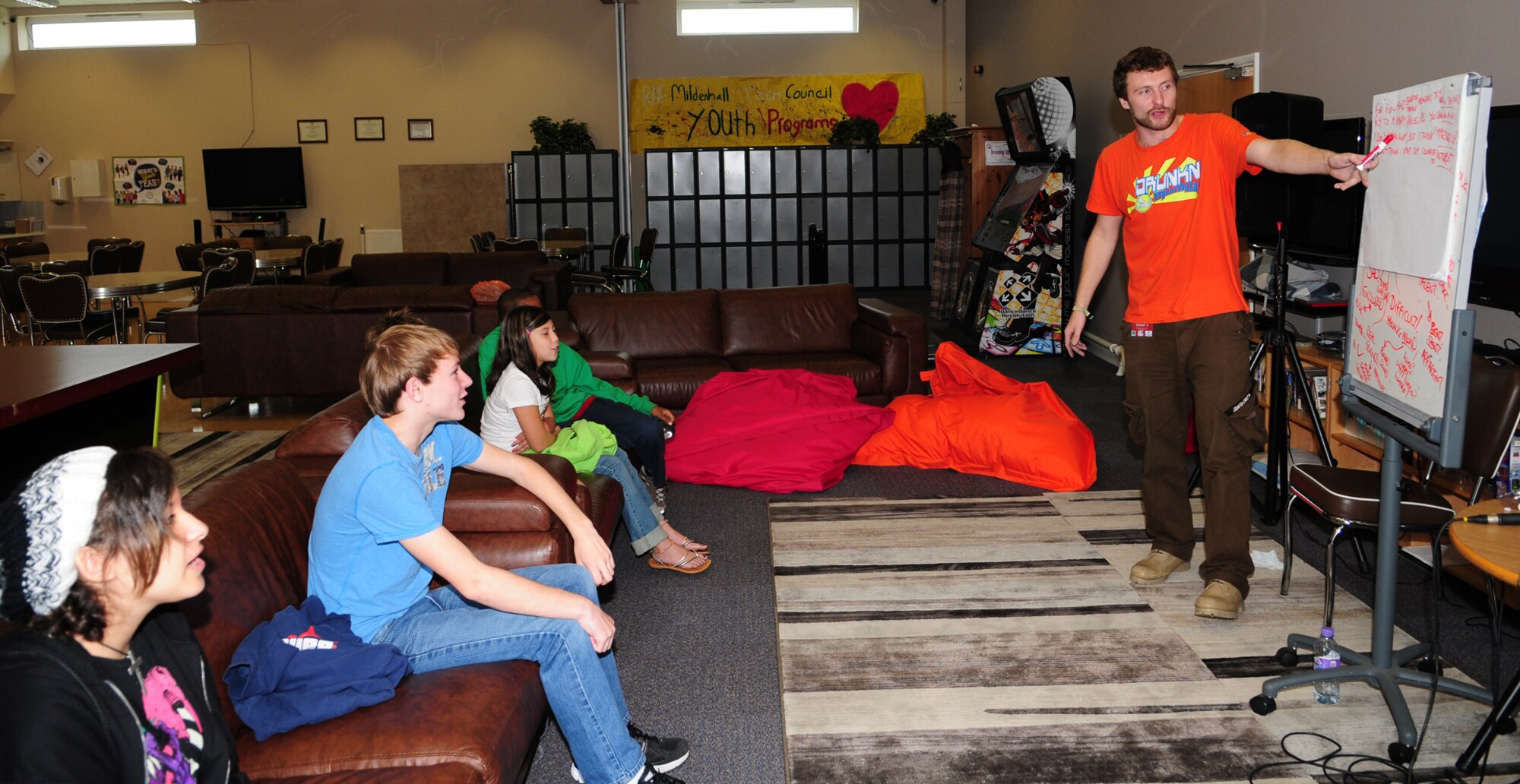 RAF MILDENHALL, England – James Taylor, right, a British professional rap artist, heads a music production workshop for children aged 9 to 16, July 17, 2012, at the teen center here. During the workshop, Taylor encouraged the youths to come up with lyrics and ideas so they could make their own rap using real-life experiences.  As part of the workshop, a DJ worked with the children to put backing tracks to their lyrics, before burning the finished work to a CD for them to keep. (U.S. Air Force photo/Karen Abeyasekere)