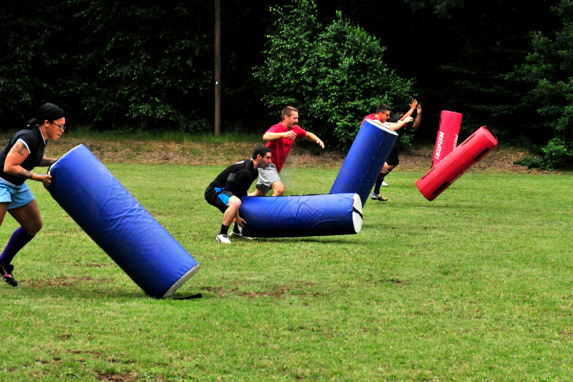 Members of the Ramstein Rogues rugby team flip equipemt duiring a strength and agility exercise during a preseason practice at the 435th Construction Training Squadron rugby pitch at Ramstein Air Base, Germany, July 12, 2012. The Rogues have two men's teams and one women's team consisting of Host Nation players, British Royal Air Force and U.S. military Soldiers, Airmen from the Kaiserslautern area and dependents. (U.S. Air Force photo/Airman 1st Class Trevor Rhynes) 

