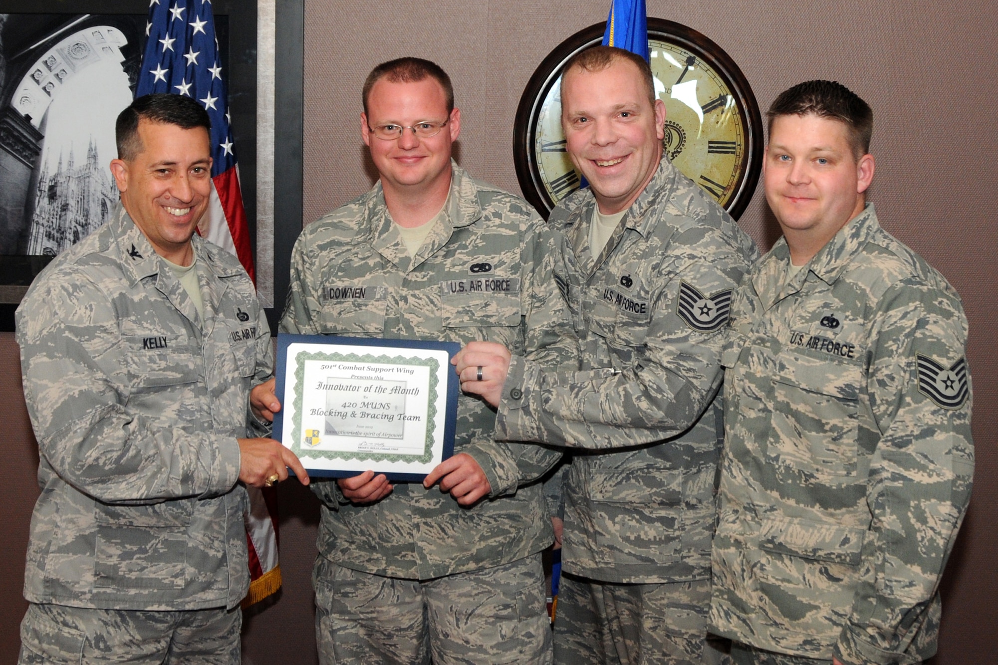 RAF CROUGHTON, United Kingdom - Col. Brian Kelly presents the Innovator of the Month award to members of the 420th Munitions Squadron Blocking and Bracing Custom Build Team. From left, Staff Sgt. Joseph Downen and Tech Sgts. Eric Perkins and Corey Holt standardized custom-built ISO containers increasing efficiency and reducing material costs by $1,200. (U.S. Air Force photo by Master Sgt. Randy Hillsgrove)