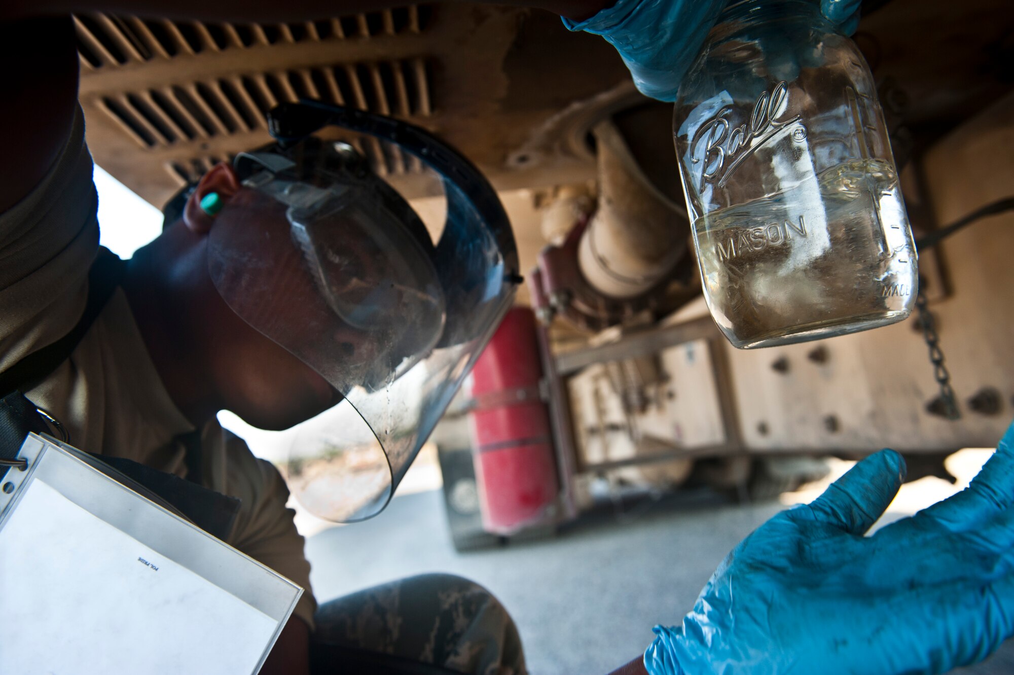 Airman 1st Class James Hancock inspects a sample of fuel from a R-11 Fuel Truck at the Transit Center at Manas, Kyrgyzstan, July 18, 2012. The 376th Expeditionary Logistics Readiness Squadron Fuels Management Flight personnel inspect fuel samples for dirt or foreign objects from every truck before distribution to aircraft. Hancock is a 376 ELRS fuels distribution journeyman deployed out of Little Rock Air Force Base, Ark. and is a native of Hampton, Va. (U.S. Air Force photo/Senior Airman Brett Clashman)