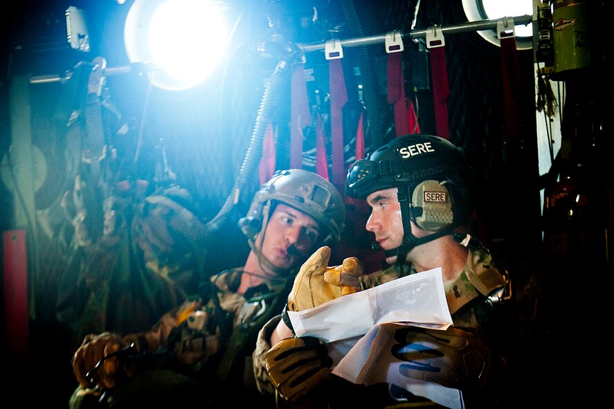 U.S. Air Force Staff Sgt. Freddie Kight, 38th Rescue Squadron pararescueman, and Capt. Daniel Catino, 38th RQS combat rescue officer, discuss mission details in an HC-130P Combat King July 16, 2012, at Moody Air Force Base, Ga. Kight and Catino each led a static line jump where they directed Airmen and ensured everyone was prepared to conduct the mission. (U.S. Air Force photo by Staff Sgt. Jamal D. Sutter/Released) 