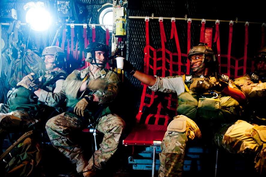U.S. Air Force Senior Airman Adrian Foster passes a cup of water to Staff Sgt. Freddie Kight while in an HC-130P Combat King July 16, 2012, at Moody Air Force Base, Ga. The Airmen are both pararescueman with the 38th Rescue Squadron who participated in a static line jump to maintain their qualifications and remain ready for possible deployments. (U.S. Air Force photo by Staff Sgt. Jamal D. Sutter/Released)