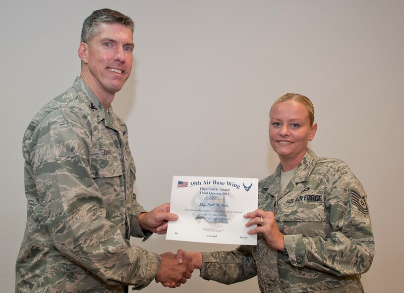 Col. Chris Craige, 39th Air Base Wing commander, left, presents Tech. Sgt. Jennifer Rowles, 39th Operations Squadron, with the third quarter Flight Safety Award July 19, 2012, at Incirlik Air Base, Turkey. Rowles accepted the award on behalf of Staff Sgt. Seth Bolz, 39th OS. The award is given to individuals or units that excelled in their safety program. (U.S. Air Force photo by Senior Airman Anthony Sanchelli/Released)
