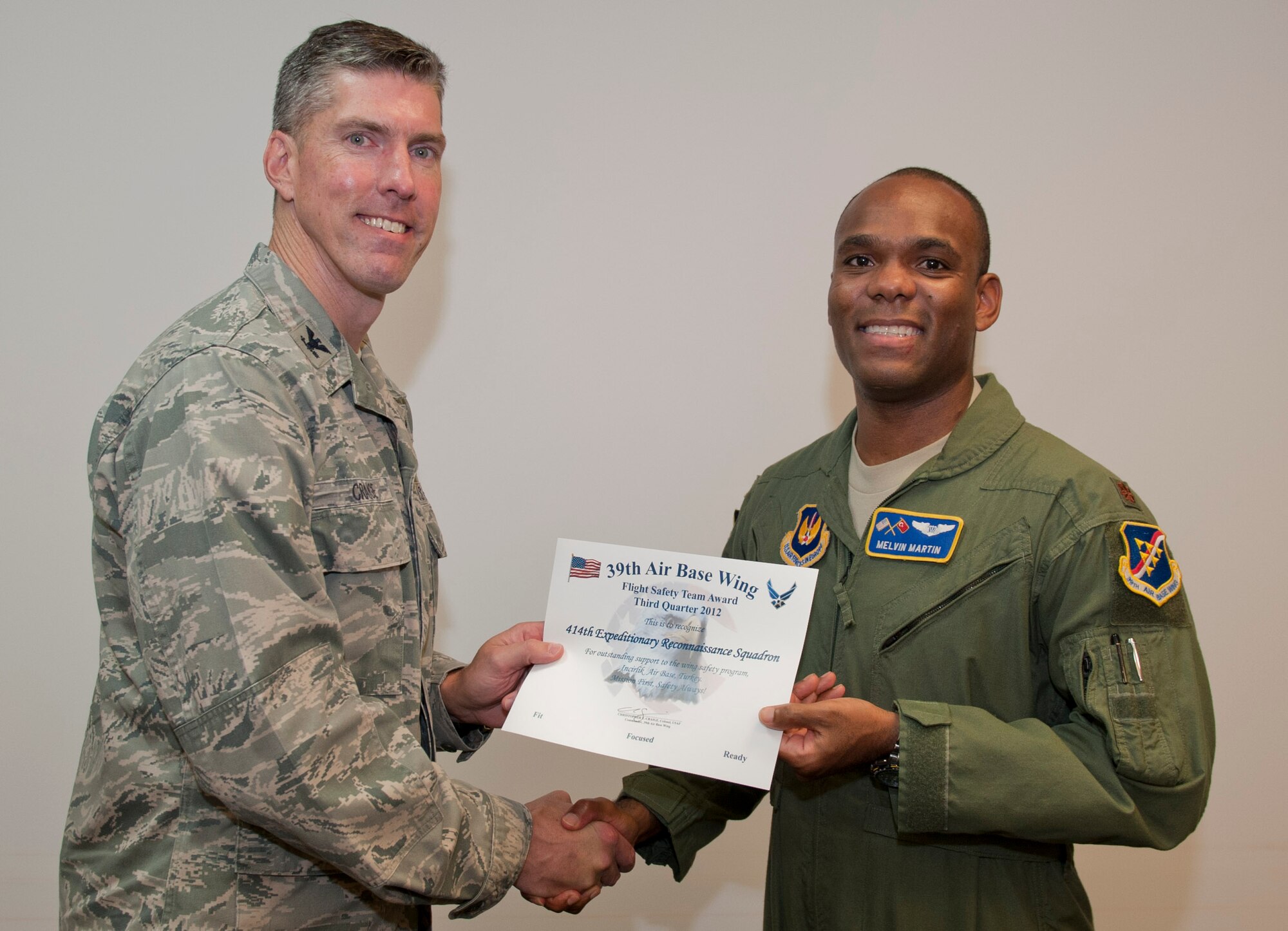 Col. Chris Craige, 39th Air Base Wing commander, left, presents Maj. Melvin, 414th Expeditionary Reconnaissance Squadron, with the third quarter Flight Safety Team Award July 19, 2012, at Incirlik Air Base, Turkey. Melvin accepted the award on behalf of the 414th ERS. The award is given to individuals or units that excelled in their safety program. (U.S. Air Force photo by Senior Airman Anthony Sanchelli/Released)