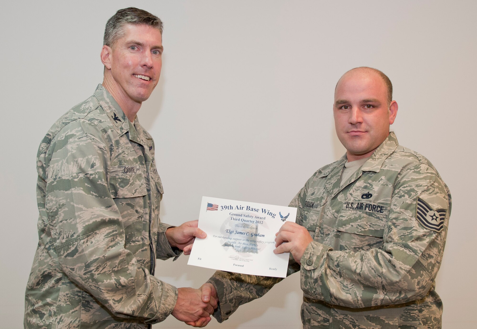 Col. Chris Craige, 39th Air Base Wing commander, left, presents Tech. Sgt. James Graham, 39th Maintenance Squadron, with the third quarter Ground Safety Award July 19, 2012, at Incirlik Air Base, Turkey. The award is given to individuals or units that excelled in their safety program. (U.S. Air Force photo by Senior Airman Anthony Sanchelli/Released)