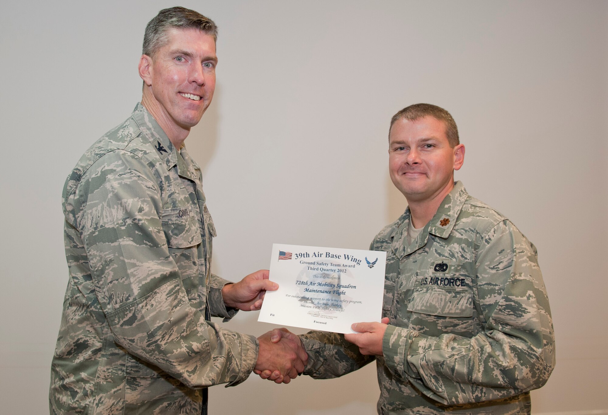 Col. Chris Craige, 39th Air Base Wing commander, left, presents Maj. Lance Vann, 728th Air Mobility Squadron, with the third quarter Ground Safety Team Award July 19, 2012, at Incirlik Air Base, Turkey. Vann accepted the award on behalf of the 728th AMS Maintenance Flight. The award is given to individuals or units that excelled in their safety program. (U.S. Air Force photo by Senior Airman Anthony Sanchelli/Released)