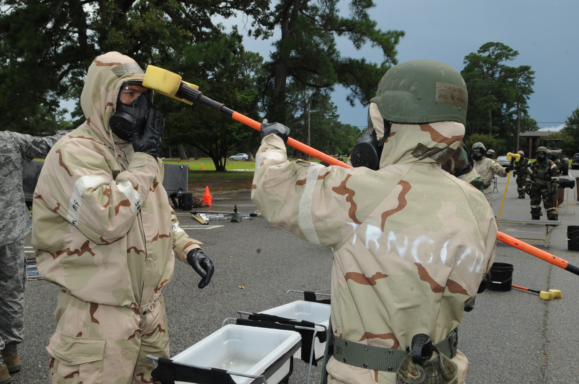 U.S. Air Force Airman 1st Class Brittany Phillips, 4th Civil Engineer Squadron engineer assistant, cleans Maj. John Beatty’s, 335th Fighter Squadron assistant director of operations, gas mask in a contamination control area on Seymour Johnson Air Force Base, N.C., July 13, 2012. The Airmen simulated procedures accomplished during post-attack reconnaissance in preparation for an upcoming operational readiness exercise. (U.S. Air Force photo/Airman 1st Class Aubrey Robinson/Released)