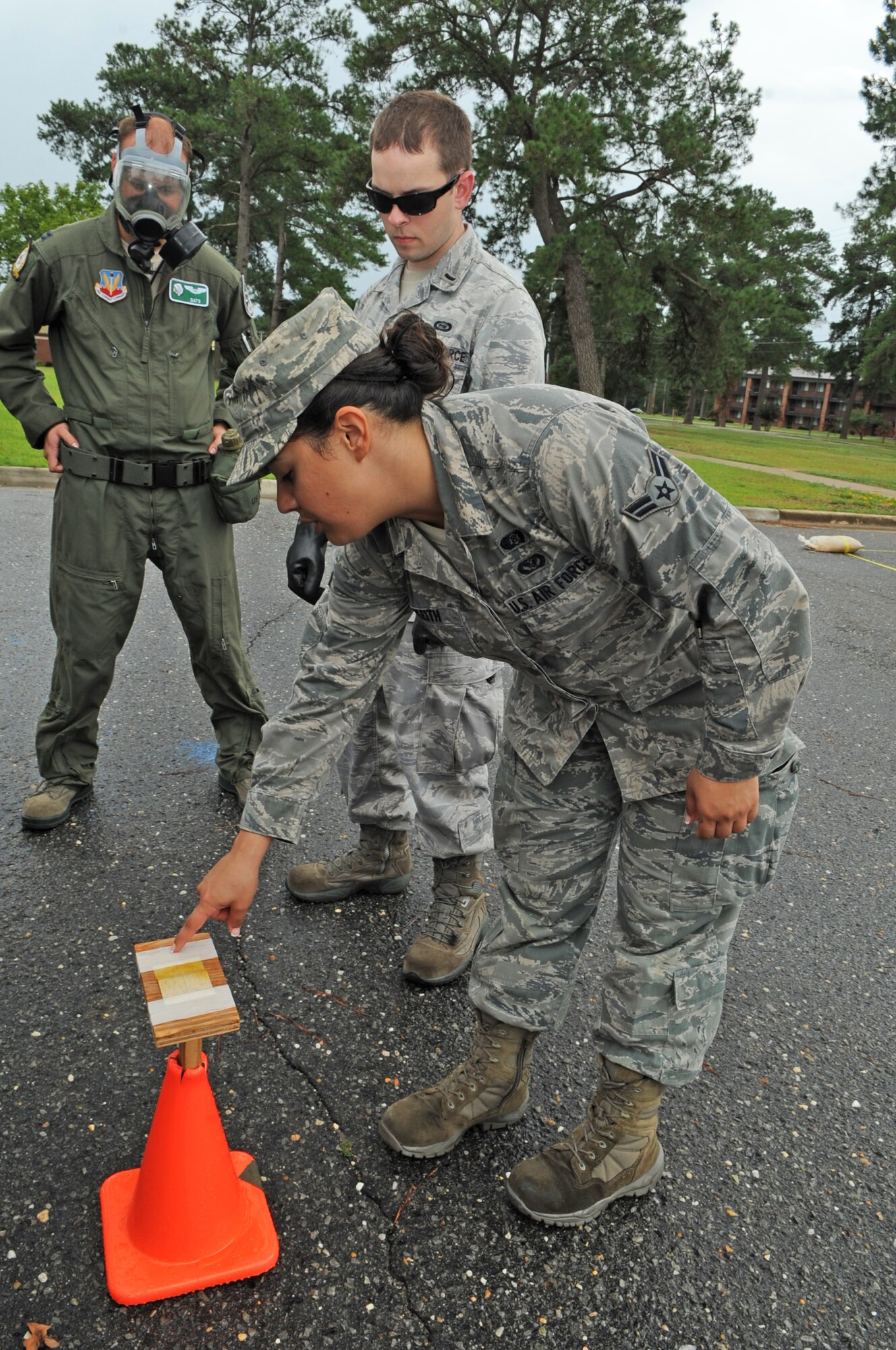 U.S. Air Force Airman 1st Class Ella Keith, 4th Civil Engineer Squadron emergency manager, explains how to place M-9 tape onto a surface in a simulated contamination control area on Seymour Johnson Air Force Base, N.C., July 13, 2012. M-9 tape is used for the detection of chemical warfare agents during pre and post-attack reconnaissance. (U.S. Air Force photo/Airman 1st Class Aubrey Robinson/Released)
