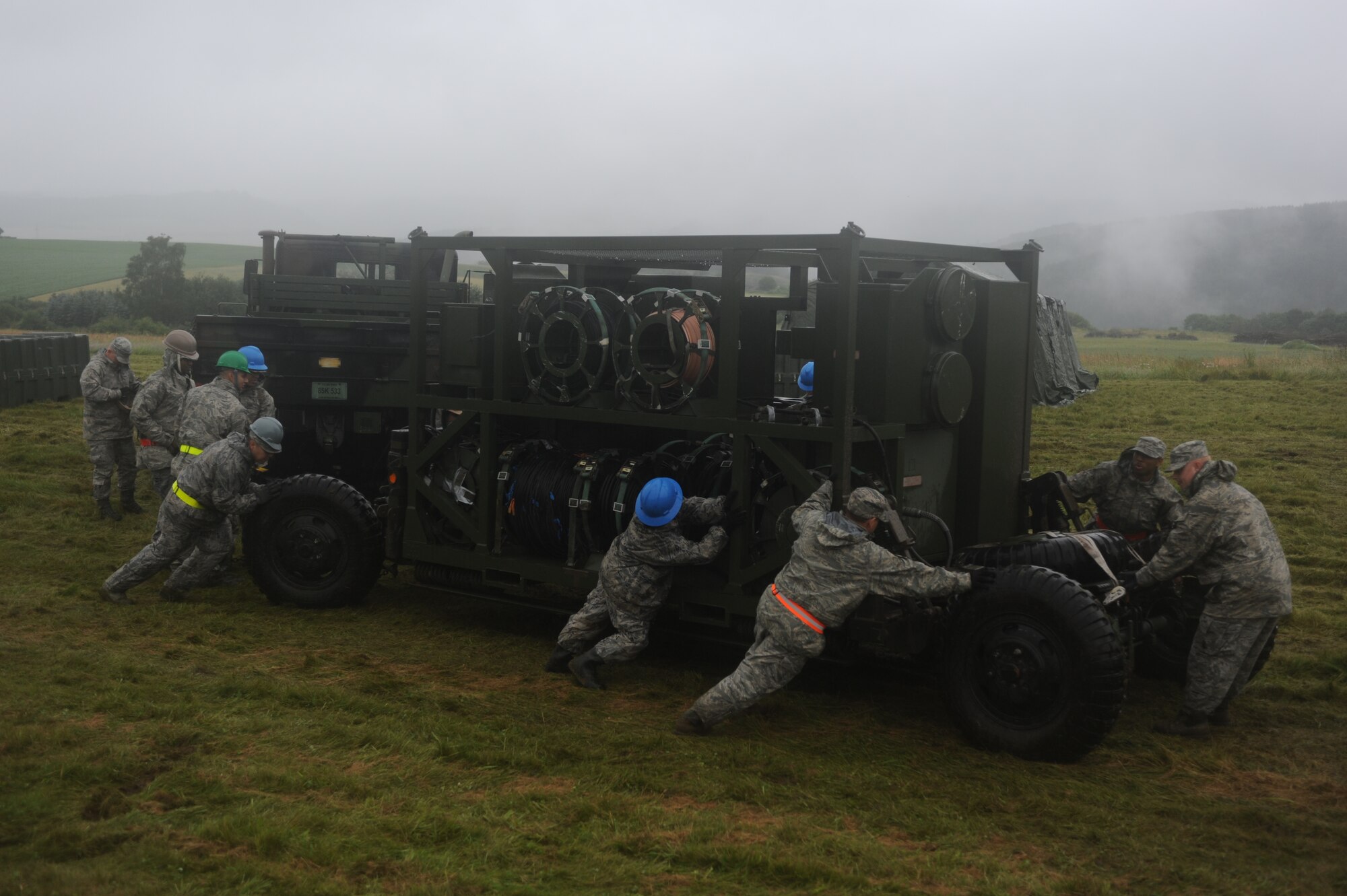 GEROLSTEIN, Germany – Airmen from the 606th Air Control Squadron push pallet of cables through the mud to their training site for Eifel Strike 2012 July 12 here. Eifel Strike is an annual field training exercise in which Airmen build a controlled radar site, and a control and reporting center to work and live from for a week. Exercises like this help Spangdahlem Airmen prepare for contingency operations around the world. It also designed to give them the practice, skills and experience they need to deploy efficiently and effectively within a moment’s notice. (U.S. Air Force photo by Senior Airman Natasha Stannard/Released)