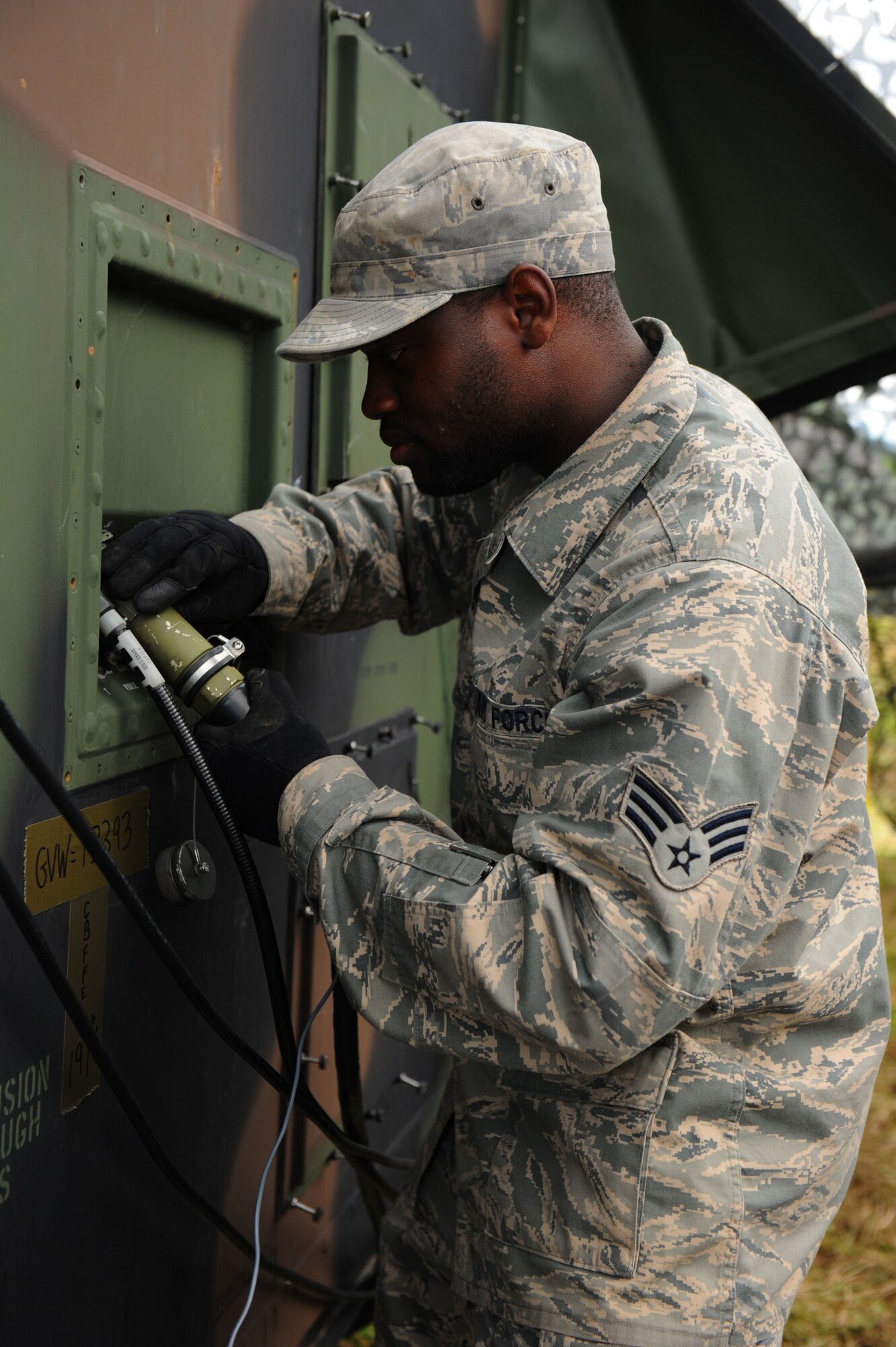 GEROLSTEIN, Germany – Senior Airman Joshua Harvey, 606th Air Control Squadron ground radar maintenance technician, connects a power cable to a radar shelter for Eifel Strike 2012 here July 16.  Eifel Strike is an annual field training exercise during which Airmen build a controlled radar site as well as a control and reporting center to work and live out of for a week. Exercises like this are designed to give Spangdahlem Airmen the practice, skills and experience they need to deploy efficiently and effectively within a moment’s notice in support of contingency operations around the world. (U.S. Air Force photo by Airman 1st Class Gustavo Castillo/Released)