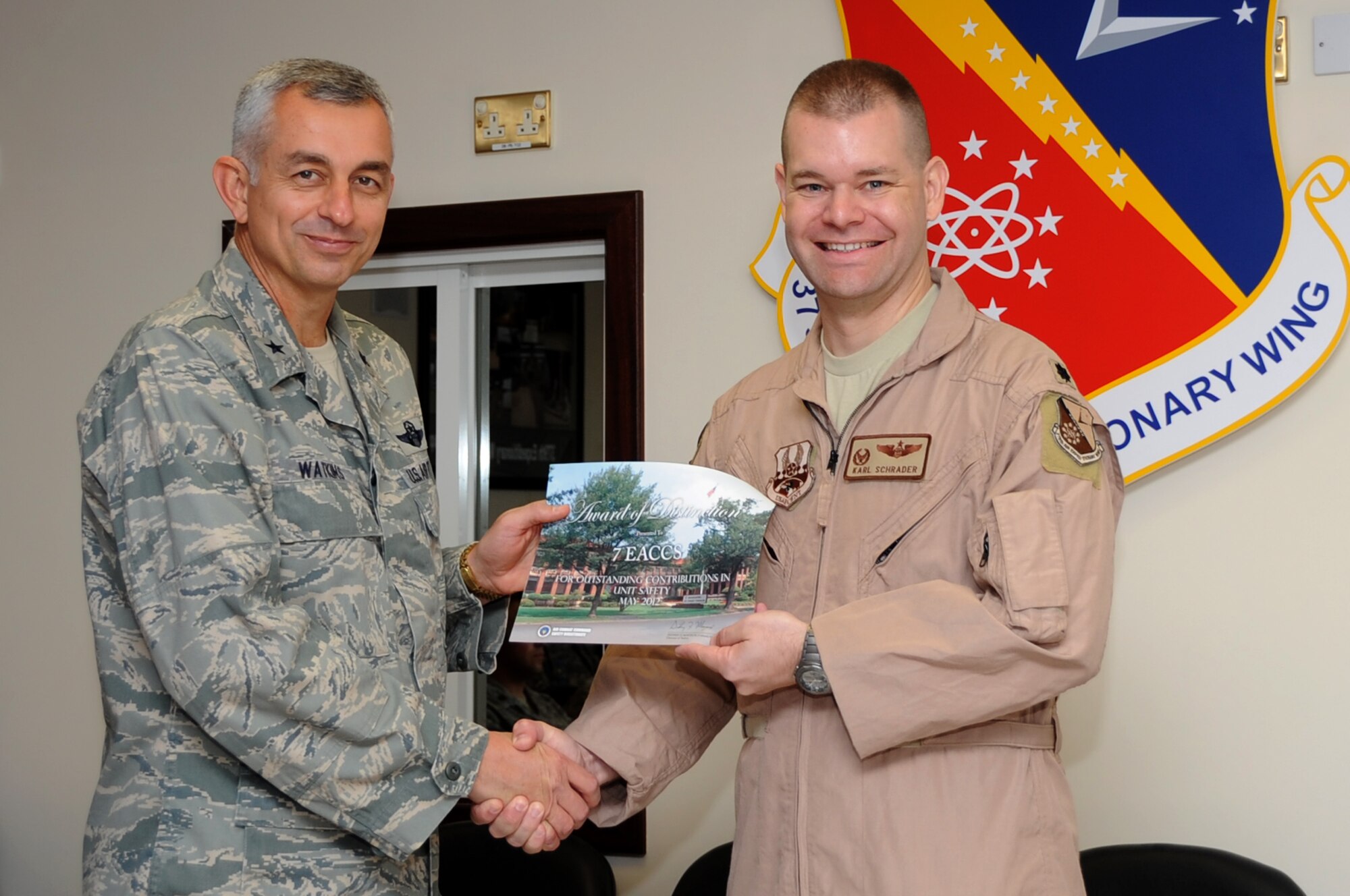 U.S. Air Force Lt. Col Karl Schrader, 7th Expeditionary Air Command and Control Squadron commander, poses with the 379th Air Expeditionary Wing Commander, Brig. Gen. Roger Watkins, after the 7th EACCS was recognized for the Unit Safety Award of Distinction, May 2012 in Southwest Asia, July 17, 2012. The 7th EACCS quickly responded to two power outages and identified the root cause. The Airmen?s immediate and effective battle management actions allowed for the safe allocation of more than 80,000 pounds of fuel and executed over 13 close air support missions. (U.S. Air Force photo/Staff Sgt. Sheila deVera)