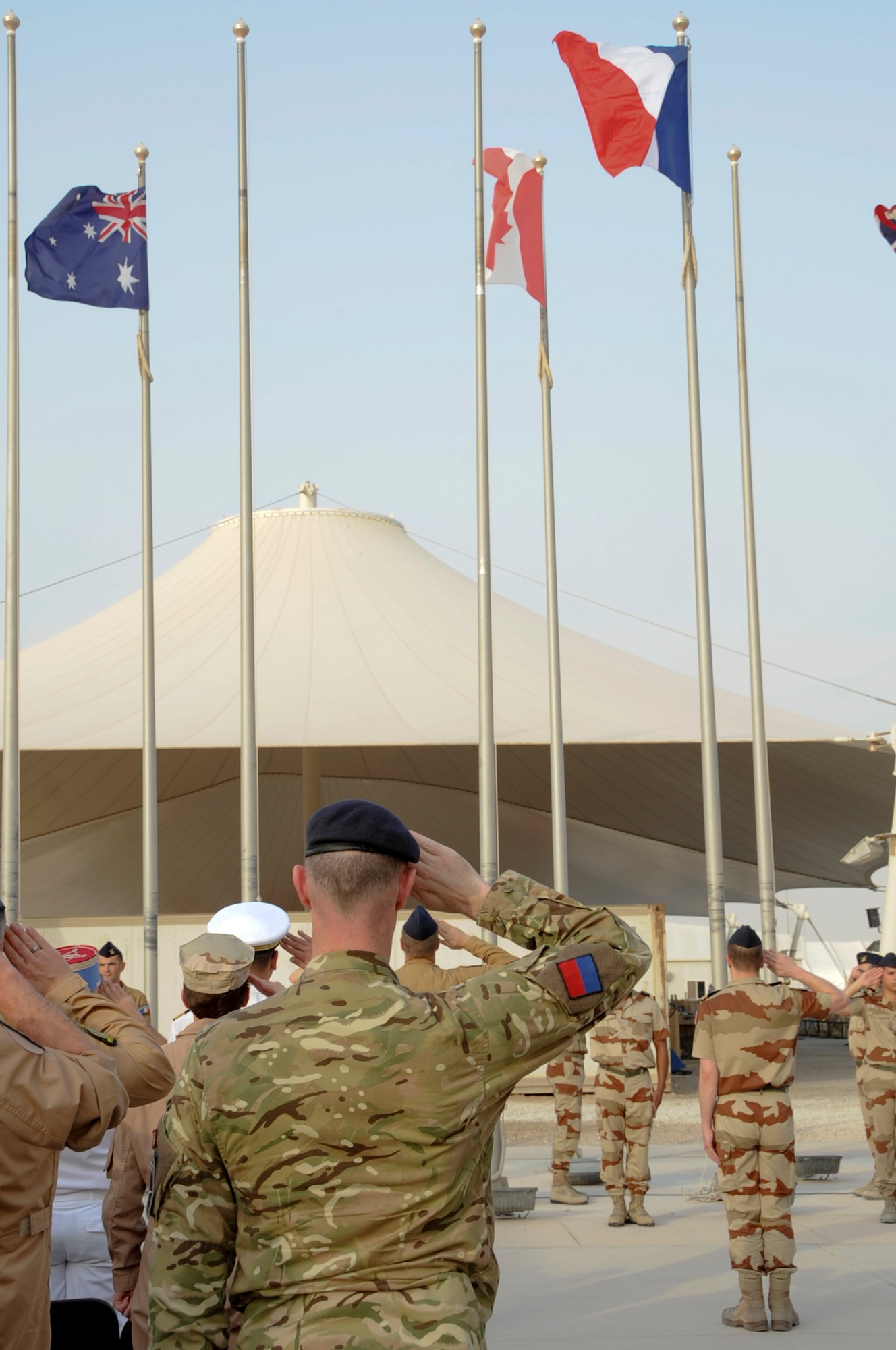 U.S. Service members and coalition partners render salutes during the French National day in Southwest Asia, July 14, 2012.  The French National day was established by law in 1880 when the royal jail ?La Bastille? was captured. Commanders from six allied nations attended the ceremony in support of the event.  (U.S. Air Force photo/Staff Sgt. Sheila deVera)