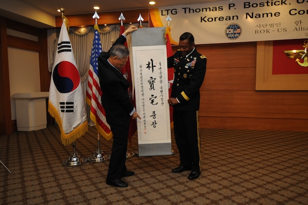 SEOUL, Republic of Korea – Suh Jin-sup, chairman of the Republic of Korea-U.S. Alliance Friendship Association, points to Korean characters on a scroll as he reads them to Lt. Gen. Thomas Bostick, the Chief of U.S. Army Engineers and Commanding General of the U.S. Army Corps of Engineers, during a "Korean naming ceremony" July 16.  Bostick was given the honorific Korean name Park Bo-taek by the association during his visit to the Republic of Korea, where he met with U.S. and Korean military officials and toured the multi-billion dollar construction project at U.S. Army Garrison Humphreys, about 40 miles south of Seoul.   Bostick's visit to the Corps of Engineers Far East District in Korea was his first since assuming command May 22.  The Corps of Engineers has about 37,600 military and civilian personnel providing project management and construction support in more than 100 countries.  U.S. Army photo by Patrick Bray.