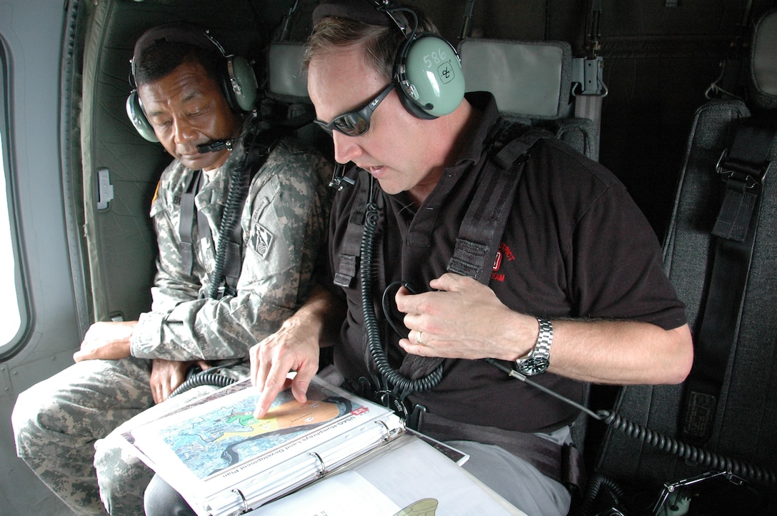 SOUTH OF SEOUL, Republic of Korea Lt. Gen. Thomas Bostick listens to Far East District area engineer Greg Reiff during a flight to U.S. Army Garrison Humphreys, as he briefs him on construction progress at the facility, about 40 miles south of Seoul.   Bostick, the Chief of U.S. Army Engineers and Commanding General of the U.S. Army Corps of Engineers, was in Korea July 16-17 meeting with U.S. and Korean military officials and touring the multi-billion dollar construction project at Humphreys. Bostick's visit to the Corps of Engineers Far East District in Korea was his first since assuming command May 22.  The Corps of Engineers has about 37,600 military and civilian personnel providing project management and construction support in more than 100 countries. U.S. Army photo by Jason Chudy.