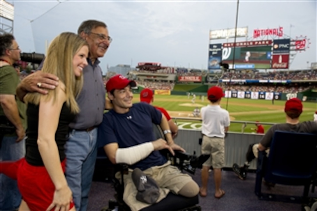 Secretary of Defense Leon E. Panetta poses for a photo with a wounded warrior and his family from Walter Reed National Military Medical Center during a Washington Nationals baseball game in Washington D.C., on July 18, 2012.  