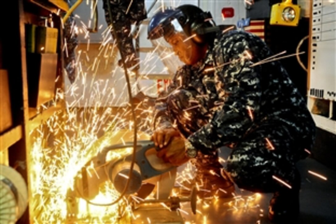 Navy Petty Officer 1st Class Choyau Troutman cuts a metal strip aboard the aircraft carrier USS George Washington in the South China Sea, July 16, 2012. The aircraft carrier departed Fleet Activities Yokosuka on May 26 to begin its 2012 patrol.