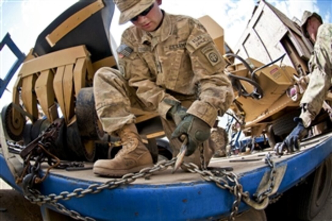 U.S. Army Spc. Alexander Istenes tightens a chain on a truck holding military equipment before the return leg of a logisitics resupply convoy on Forward Operating Base Arian in Afghanistan's Ghazni province, July 9, 2012. Istenes, a truck driver, is assigned to the 82nd Airborne Division's 307th Brigade Support Battalion, 1st Brigade Combat Team.