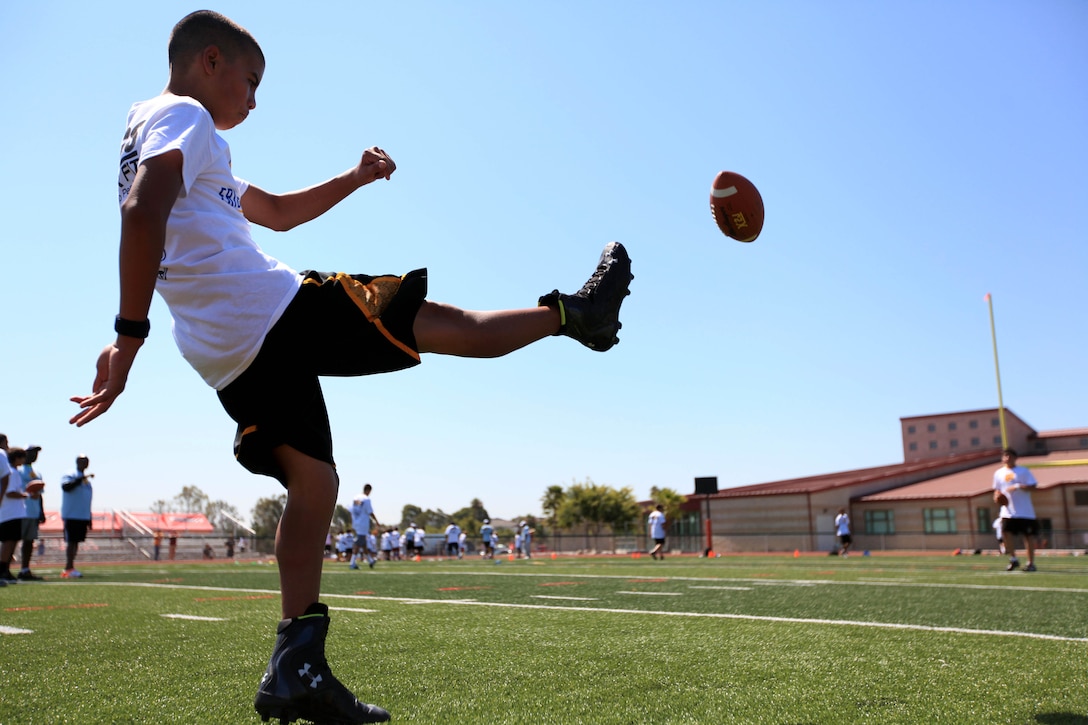 Joseph Ramirez, 13, kicks a football during a punting drill. Young aspiring athletes, ages 6-17, received coaching from former professional athletes during the 2nd Annual Eric Dickerson Foundation Youth Football and Cheer Camp at Camp Pendleton's Paige Fieldhouse, July 19 and 20.