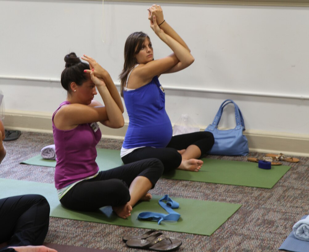 Participants at the “It’s All About You,” mid-deployment workshop at the Russell Marine and Family Center aboard the base practice newly learned yoga techniques, July 7. The workshop focused on teaching patrons how to bring the luxury and relation of a spa into their homes.