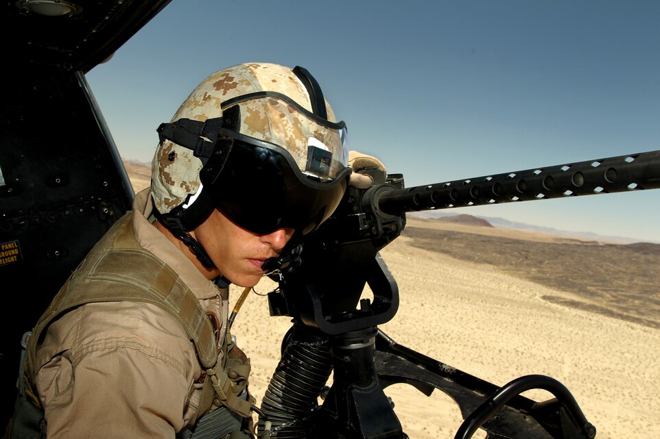 Lance Cpl. Michael Morris, a crew chief with Marine Light Attack Helicopter Squadron 167, leans out of a UH-1Y huey to help guide the pilots to a safe landing zone. HMLA-167 inserted Marines with 1st Battalion, 1st Marine Regiment, Weapons Company, scout sniper platoon, and Marines with 3rd Battalion, 9th Marine Regiment, Weapons Company, scout sniper platoon, to landing zones in support of Enhance Mojave Viper to reinforce a simiulated attack near Lead Mountain and the Lava training areas.