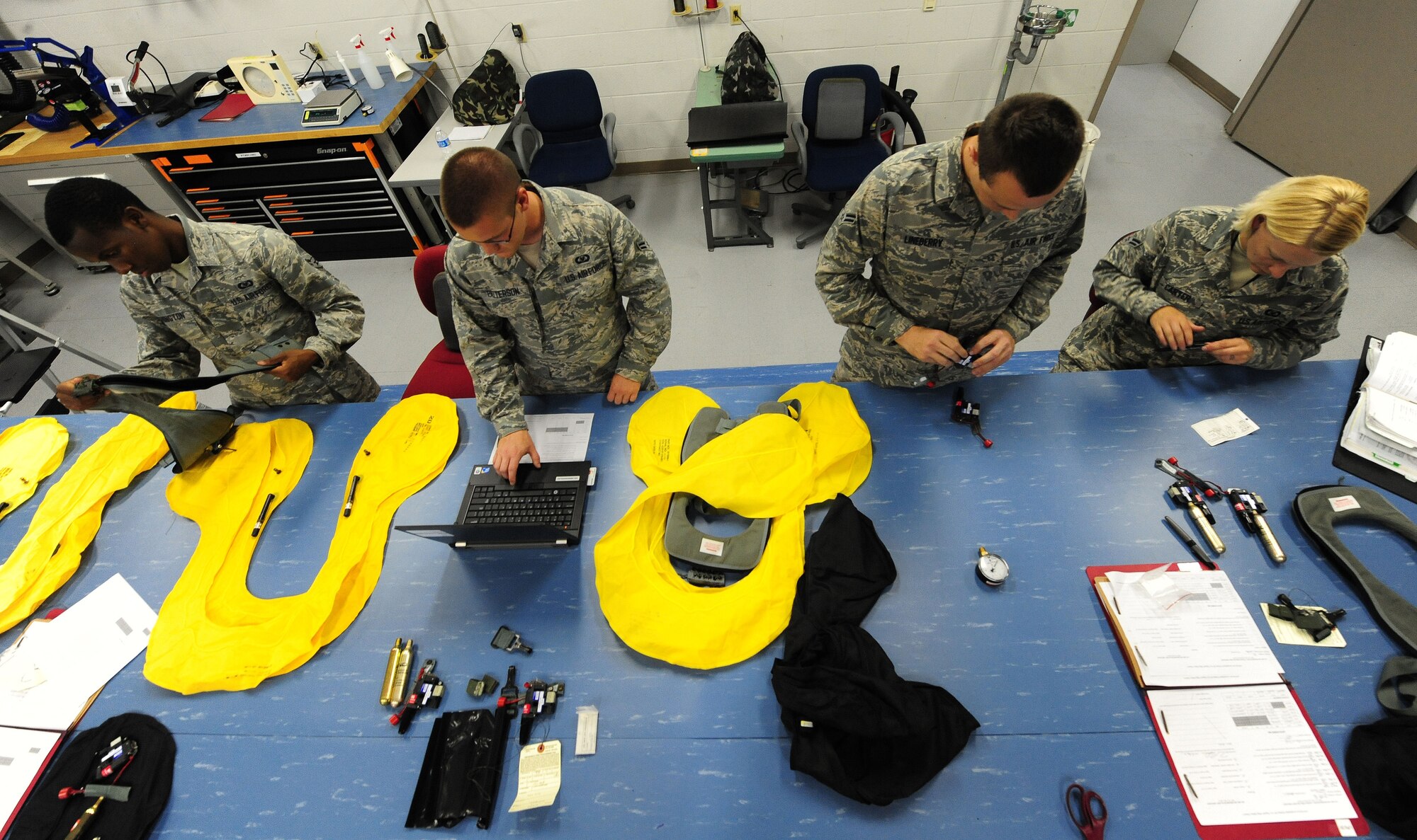 WHITEMAN AIR FORCE BASE, Mo. -- Members of the 509th Operations Support Squadron Aircrew Flight Equipment shop perform routine inspections on aircrew flight equipment July 9. A pilot’s safety depends on the reliability of equipment assembled by AFE Airmen. (U.S. Air Force photo/Senior Airman Nick Wilson) (Released)
