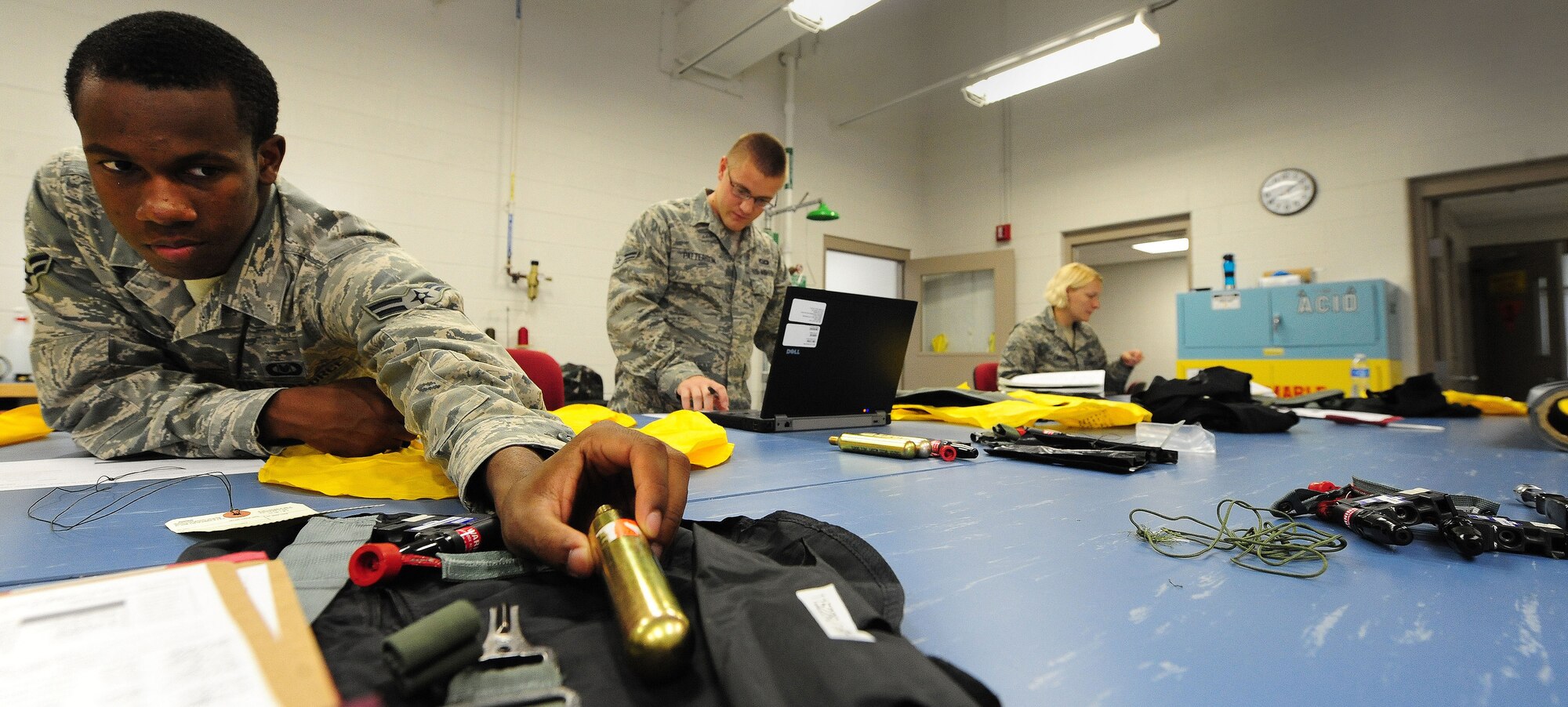 WHITEMAN AIR FORCE BASE, Mo. -- Airman 1st Class Dalvin Washington, Airman 1st Class Christopher Lineberry and Airman 1st Class Sarah Lineberry, 509th Operations Support Squadron Aircrew Flight Equipment apprentices, perform maintenance on life support equipment July 9.  AFE personnel are in charge of ensuring all flight equipment is in perfect working order, from parachutes to oxygen masks. (U.S. Air Force photo/Senior Airman Nick Wilson) (Released)