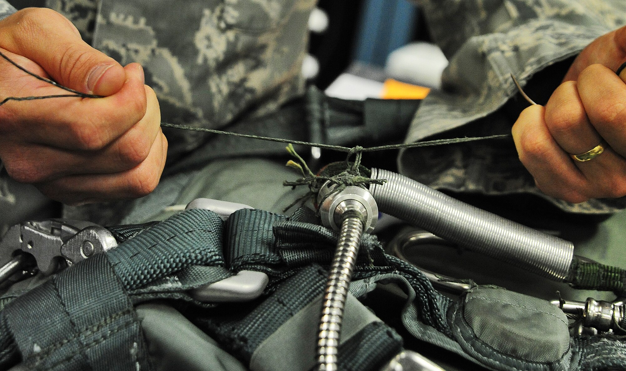 WHITEMAN AIR FORCE BASE, Mo. -- Senior Airman Justin Dunford, 509th Operations Support Squadron Aircrew Flight Equipment journeyman, ties a string on a set of life support equipment July 3. AFE Airmen ensure pilots are equipped with all equipment necessary for in-flight safety. (U.S. Air Force photo/Senior Airman Nick Wilson) (Released)