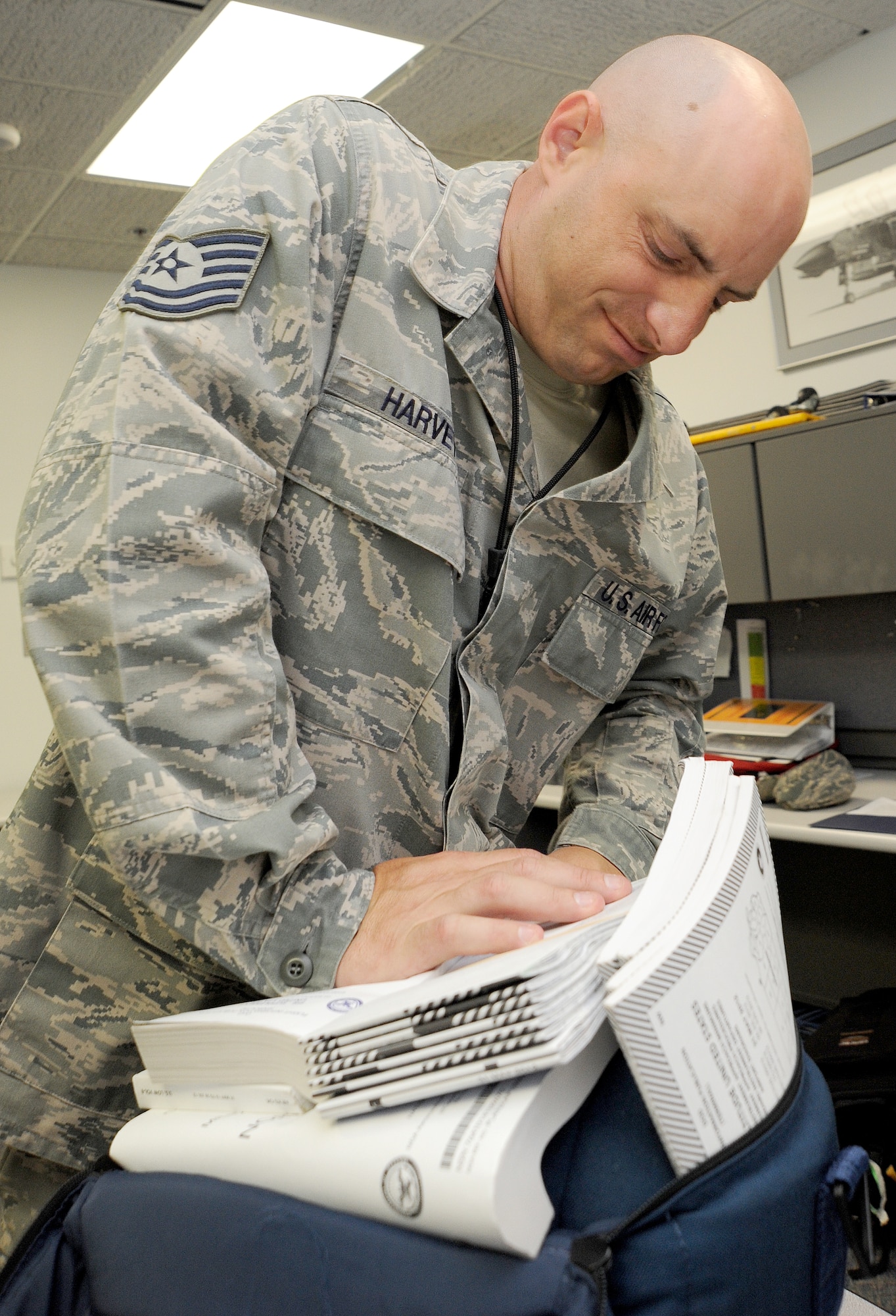 WHITEMAN AIR FORCE BASE, Mo. -- Tech. Sgt. Keith Harvey, 509th Operations Support Squadron Combat Crew Communications section chief, puts together a worldwide flip bag for a B-2 Spirit aircrew member, July 3. The flip bag has flight information kits that give B-2 aircrew members worldwide coverage and safety in the event of an inflight emergency. (U.S. Air Force photo/Senior Airman Nick Wilson) (Released)