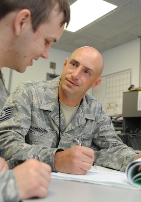 WHITEMAN AIR FORCE BASE, Mo. -- Tech. Sgt. Keith Harvey, 509th Operations Support Squadron Combat Crew Communications section chief, reviews training records in the Combat Crew Communications Career Field Education and Training Plan with Airman Joshua Biros, 509th OSS Combat Crew Communications technician, July 3. The CFETP ensures Airmen are qualified to complete the tasks assigned to them without assistance. (U.S. Air Force photo/Senior Airman Nick Wilson) (Released)