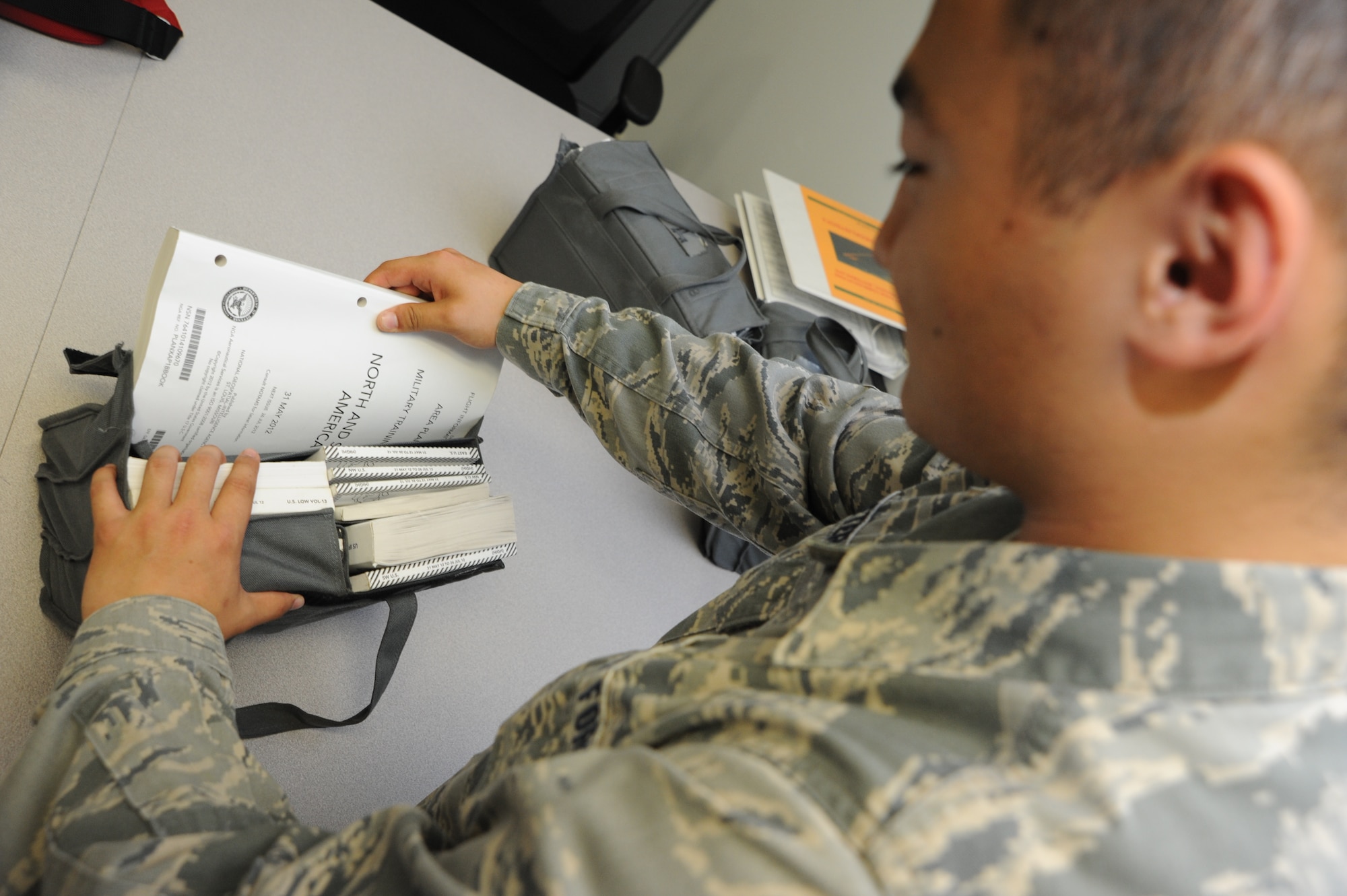 WHITEMAN AIR FORCE BASE, Mo. -- Airman 1st Class Michael Peters, 509th Operations Support Squadron Combat Crew Communications technician, prepares a flight information kit for a B-2 Spirit flight, July 3. The kit ensures that the aircrew members flying have the proper publications necessary to reach their destination. (U.S. Air Force photo/Senior Airman Nick Wilson) (Released)