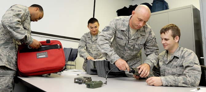 WHITEMAN AIR FORCE BASE, Mo. -- Airmen from the 509th Operations Support Squadron Combat Crew Communications flight, inspect a daily communications kit, July 3. The inspection ensures all communications information has been verified and ready for future missions. (U.S. Air Force photo/Senior Airman Nick Wilson) (Released)