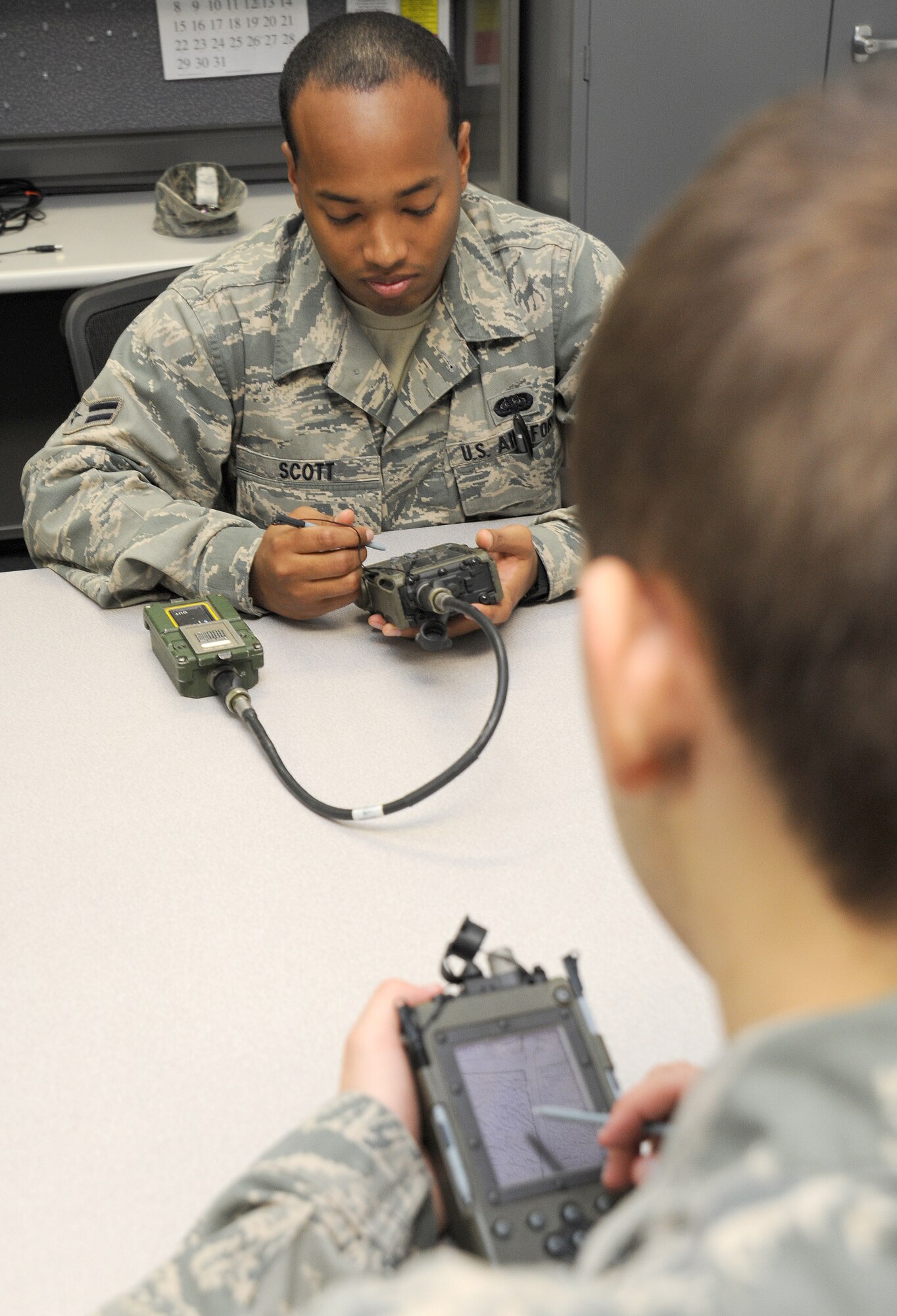 WHITEMAN AIR FORCE BASE, Mo. -- Airman 1st Class Kenneth Scott and Airman Joshua Biros, 509th Operations Support Squadron Combat Crew Communications technicians, transfer communications security keys on a key loader to prep for B-2 Spirit missions throughout the week, July 7. The transfer ensures that B-2 sorties generated during the week have the communication keys necessary to complete the mission. (U.S. Air Force photo/Senior Airman Nick Wilson) (Released)