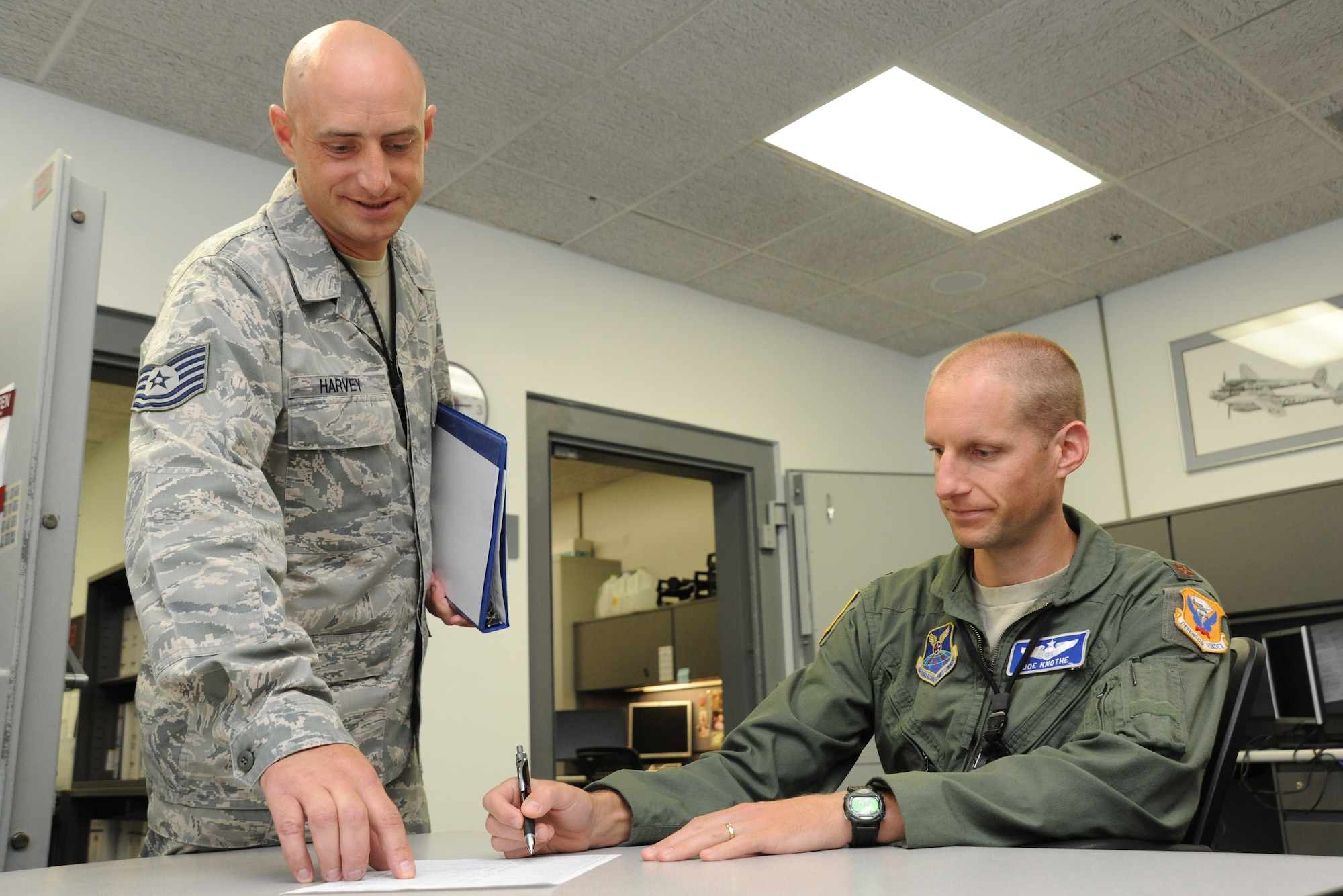 WHITEMAN AIR FORCE BASE, Mo. -- Tech. Sgt. Keith Harvey, 509th Operations Support Squadron Combat Crew Communications section chief, gives a step-by-step aircrew communications security training session to Maj. Joseph Knothe, 509th OSS assistant director of operations, July 3. The training ensures the aircrew member understands he knows the communications security procedures needed while in-flight. (U.S. Air Force photo/Senior Airman Nick Wilson) (Released)