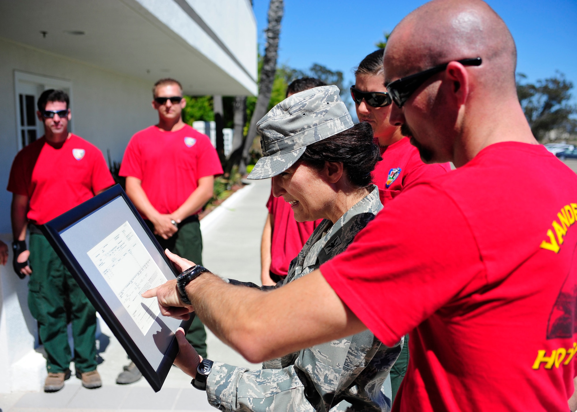 VANDENBERG AIR FORCE BASE, Calif. --  Col. Nina Armagno, 30th Space Wing commander, shows Kristin Halbeisen and Jesse Hendricks, members of the Vandenberg Hot Shots, details of their original assignment order for the Waldo Canyon Fire in Colorado. The Hot Shots were fighting wildfires in Colorado and Wyoming, which burned 29,168 acres and destroyed nearly 360 homes in Colorado. (U.S. Air Force photo/Michael Peterson)