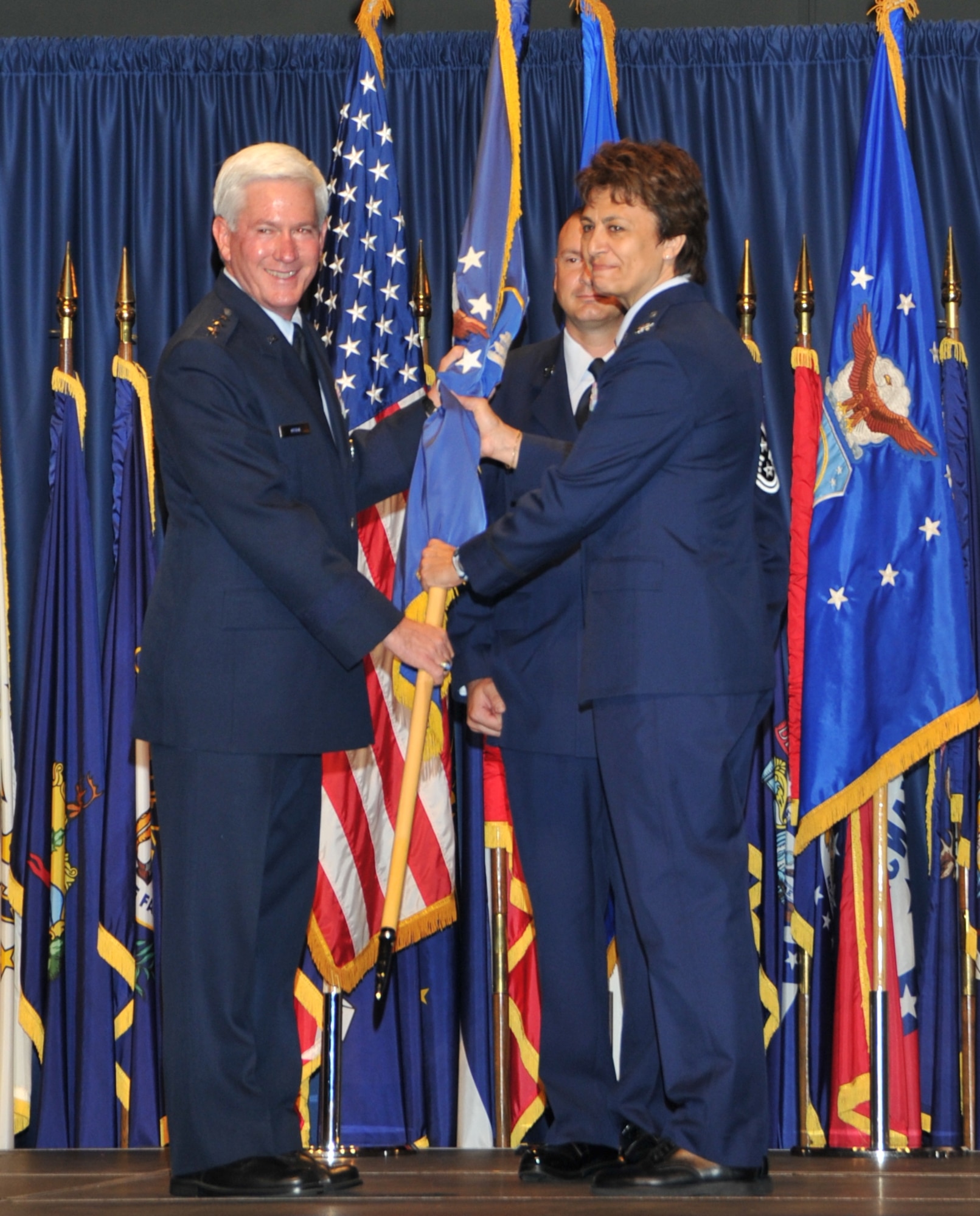 Lt. Gen. Tom Owen, Aeronautical Systems Center commander, hands the 88th Air Base Wing guidon to Col. Cassie B. Barlow, who now commands more than 5,000 Air Force military, civilian and contractor employees at Wright-Patterson Air Force Base. 