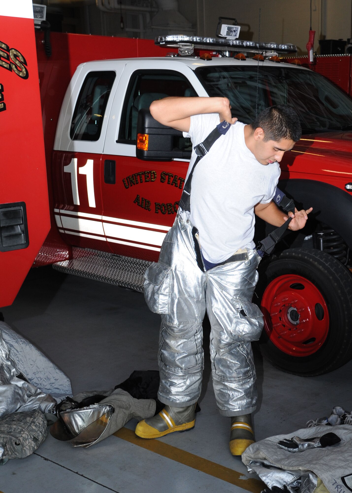 Senior Airman Justin Rodriguez, 14th Civil Engineer Squadron quick-dons firefighting gear during a crash rescue drill on July 17. 14th CES firefighters are prepared 24 hours a day, seven day a week crash rescue ops plus five days a week Gunshy Auxillary Airfield. (U.S. Air Force photo/Senior Airman Chase Hedrick)