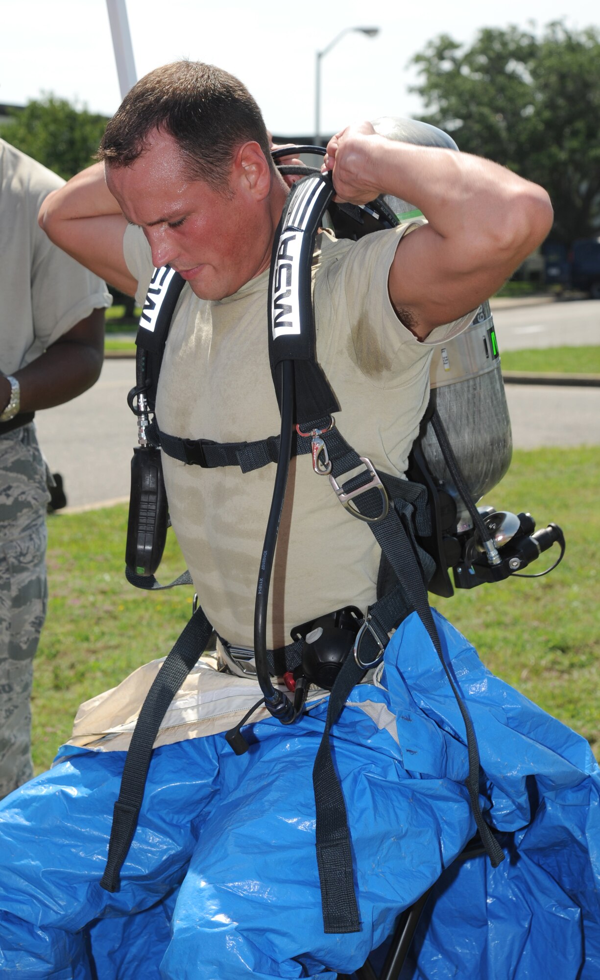 Airman 1st Class Christopher Lecomte, a Keesler firefighter, puts on a hazmat suit for entering the “contaminated” area to retrieve “victims” during an exercise July 18, 2012, at Keesler Air Force Base, Miss.  Keesler held the three-day exercise to test the response of base personnel. In the exercise scenario, a disgruntled base employee sprayed harmful chemicals on Airmen in the Triangle training area injuring several people. Witnesses contacted 911 and within minutes, members of the 81st Security Forces Squadron apprehended the individual and first responders began decontamination and treatment of the victims. (U.S. Air Force photo by Kemberly Groue)