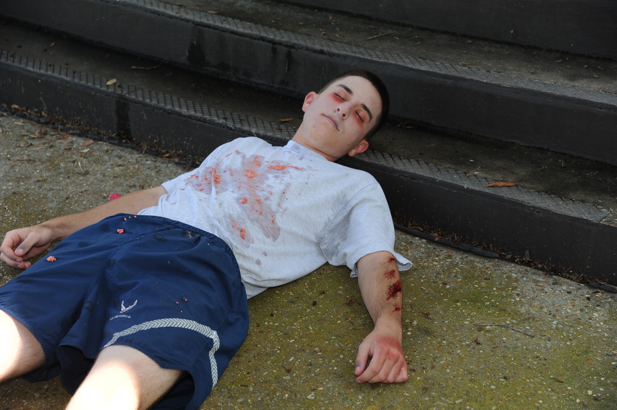 Airman 1st Class Brantly Riebe, 336th Training Squadron, portrays a victim of a chemical attack who is unconscious during an exercise July 18, 2012, at Keesler Air Force Base, Miss. Keesler held the three-day exercise to test the response of base personnel. In the exercise scenario, a disgruntled base employee sprayed harmful chemicals on Airmen in the Triangle training area injuring several people. Witnesses contacted 911 and within minutes, members of the 81st Security Forces Squadron apprehended the individual and first responders began decontamination and treatment of the victims. (U.S. Air Force photo by Kemberly Groue)