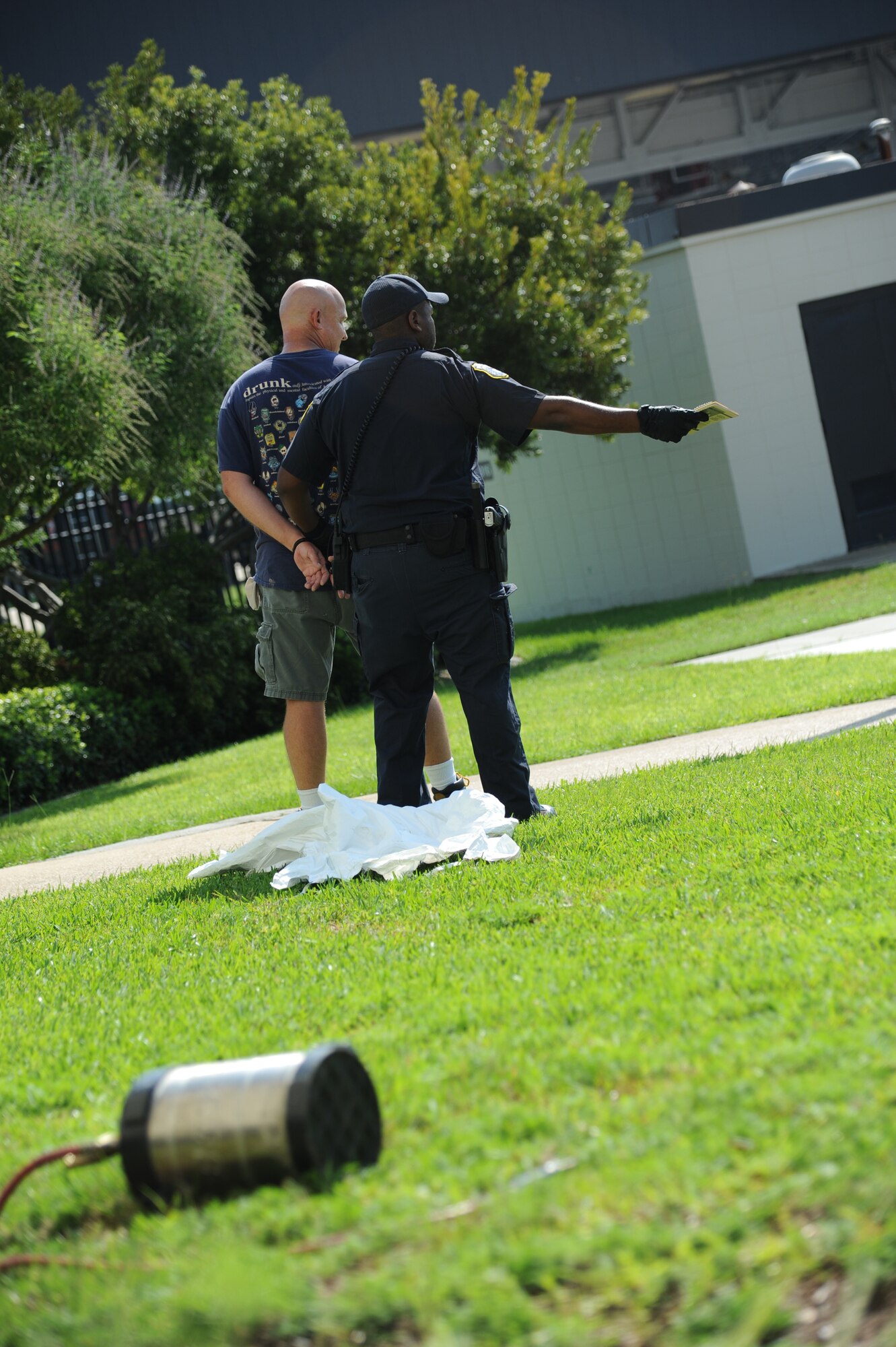 Master Sgt. Robert Denton, 81st Training Support Squadron, portrays a terrorist that is being apprehended by Officer Sheenon Rhome, 81st Security Forces Squadron, after he sprayed several “victims” with a chemical during an exercise July 18, 2012, at Keesler Air Force Base, Miss.  Keesler held the three-day exercise to test the response of base personnel. Keesler held the three-day exercise to test the response of base personnel. In the exercise scenario, a disgruntled base employee sprayed harmful chemicals on Airmen in the Triangle training area injuring several people. Witnesses contacted 911 and within minutes, members of the 81st Security Forces Squadron apprehended the individual and first responders began decontamination and treatment of the victims. (U.S. Air Force photo by Kemberly Groue)