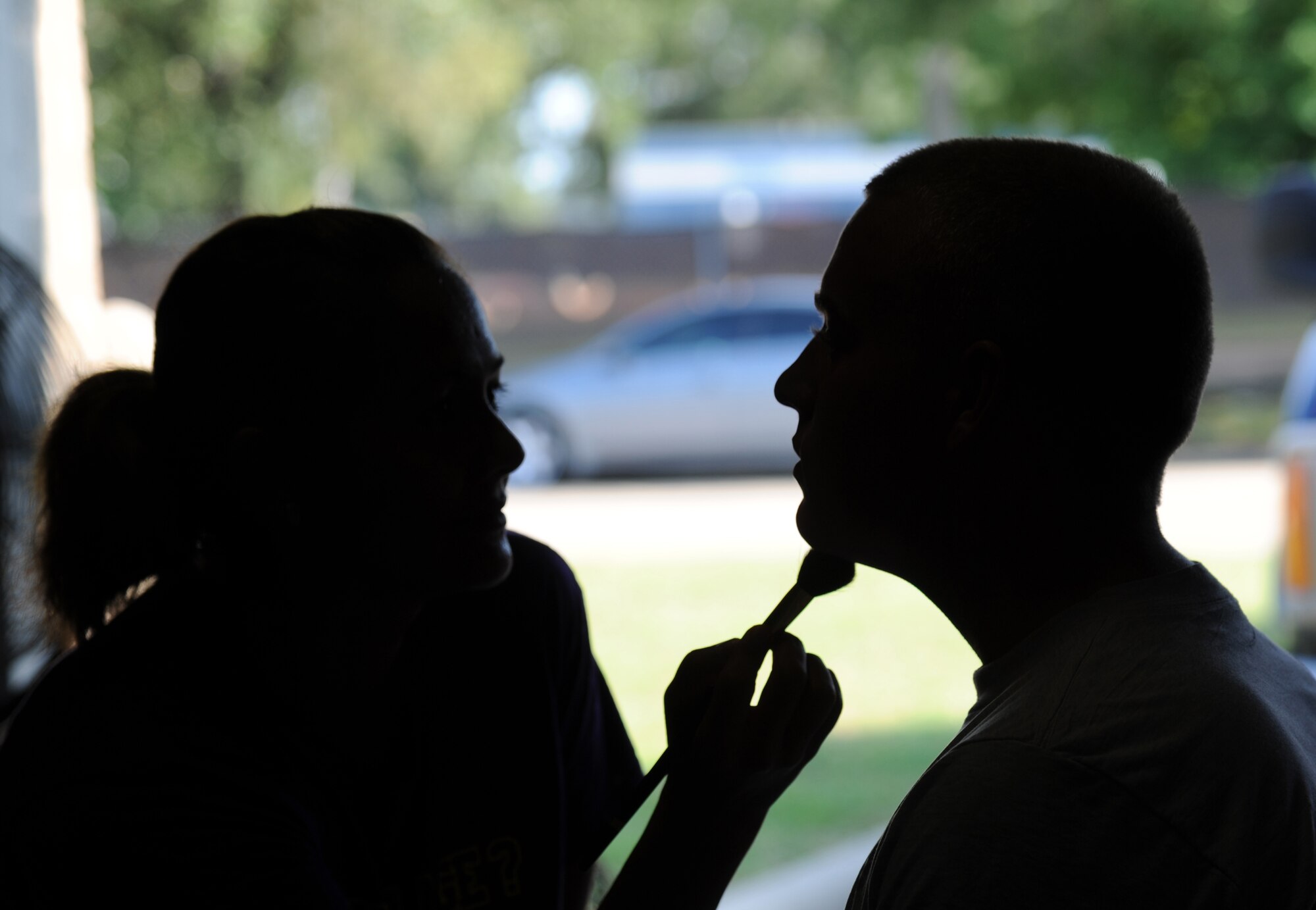 Tech. Sgt. Caroline Bunce, 81st Dental Squadron and a moulage artist for the exercise evaluation team, applies moulage to Airman Basic Dillon Hall, 336th Training Squadron, for a more realistic effect during an exercise July 18, 2012, at Keesler Air Force Base, Miss. Keesler held the three-day exercise to test the response of base personnel. Keesler held the three-day exercise to test the response of base personnel. In the exercise scenario, a disgruntled base employee sprayed harmful chemicals on Airmen in the Triangle training area injuring several people. Witnesses contacted 911 and within minutes, members of the 81st Security Forces Squadron apprehended the individual and first responders began decontamination and treatment of the victims. (U.S. Air Force photo by Kemberly Groue)