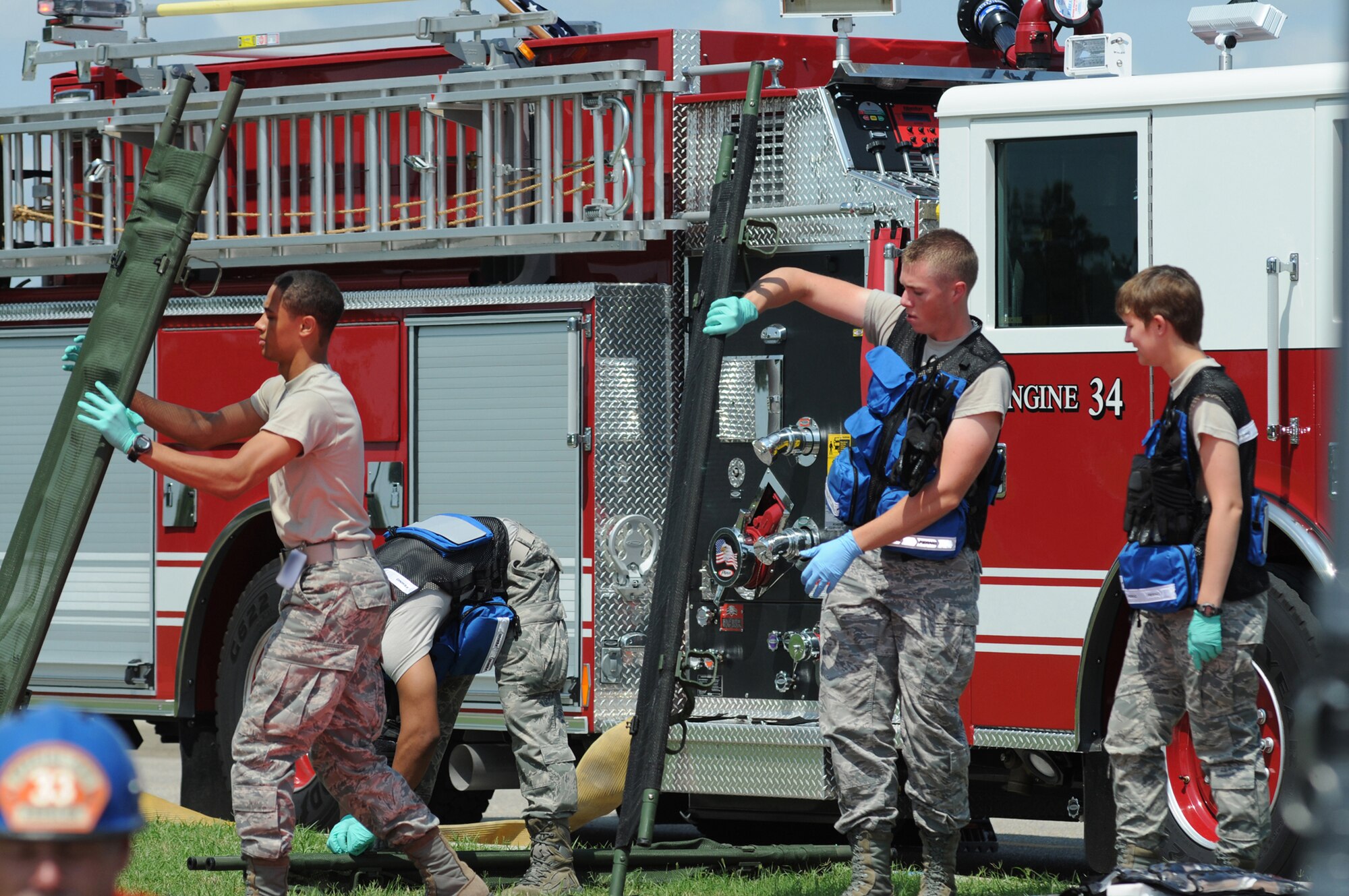 Airmen 1st Class Art Easterling, James Rodriguez, Jason Parker and Demi Cook, 81st Aerospace Medicine Squadron, secure stretchers on scene for exercise victims July 18, 2012, at Keesler Air Force Base, Miss. Keesler held the three-day exercise to test the response of base personnel. In the exercise scenario, a disgruntled base employee sprayed harmful chemicals on Airmen in the Triangle training area injuring several people. Witnesses contacted 911 and within minutes, members of the 81st Security Forces Squadron apprehended the individual and first responders began decontamination and treatment of the victims. (U.S. Air Force photo by Kemberly Groue)