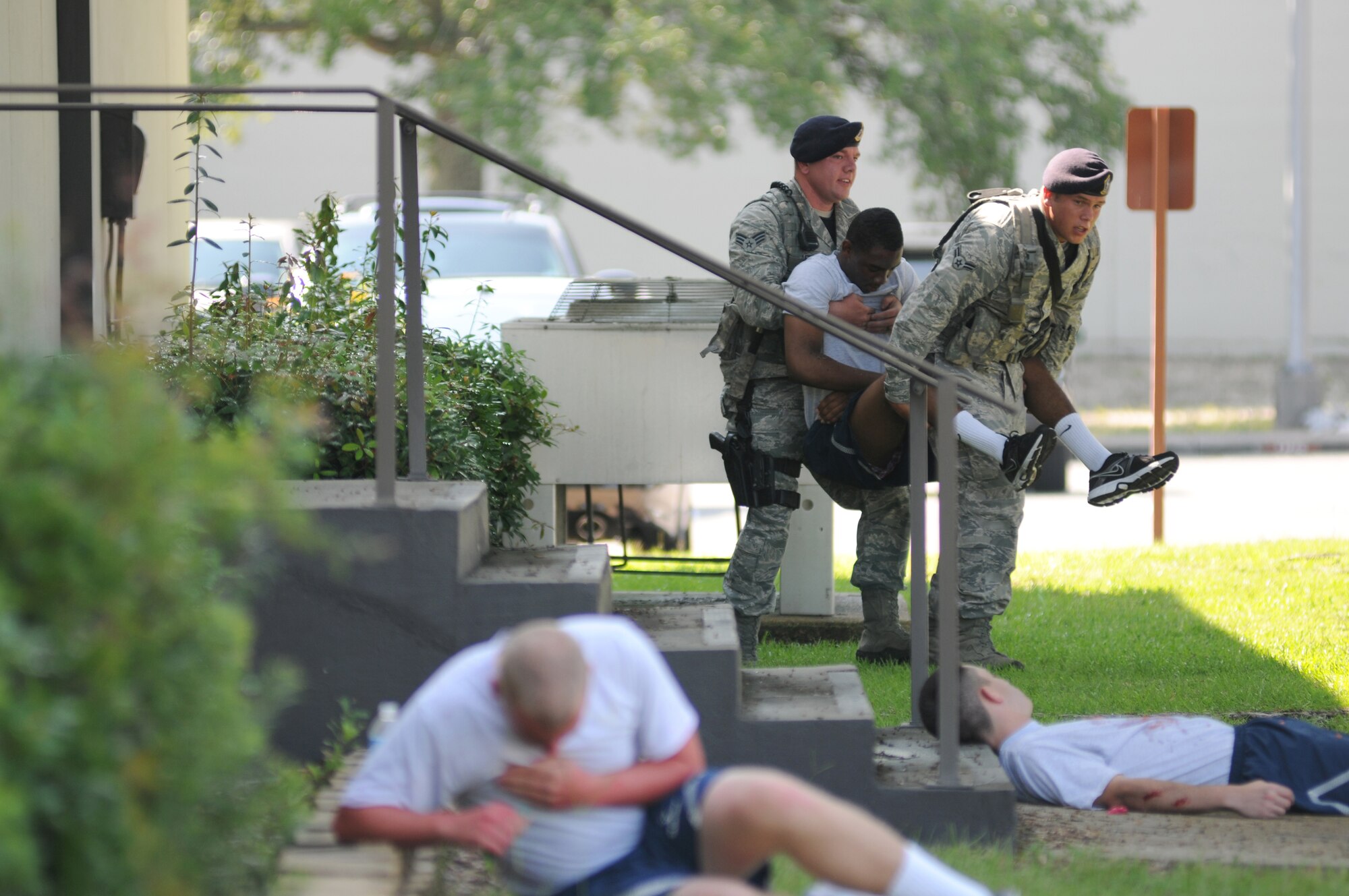 Senior Airman Aaron Bradley and Airman 1st Class Wesley Mory, 81st Security Forces Squadron, carry an exercise “victim,” Airman Basic Marlon Lowery, 336th Training Squadron, to safety during an exercise July 18, 2012, at Keesler Air Force Base, Miss.  Keesler held the three-day exercise to test the response of base personnel. In the exercise scenario, a disgruntled base employee sprayed harmful chemicals on Airmen in the Triangle training area injuring several people. Witnesses contacted 911 and within minutes, members of the 81st Security Forces Squadron apprehended the individual and first responders began decontamination and treatment of the victims. (U.S. Air Force photo by Kemberly Groue)