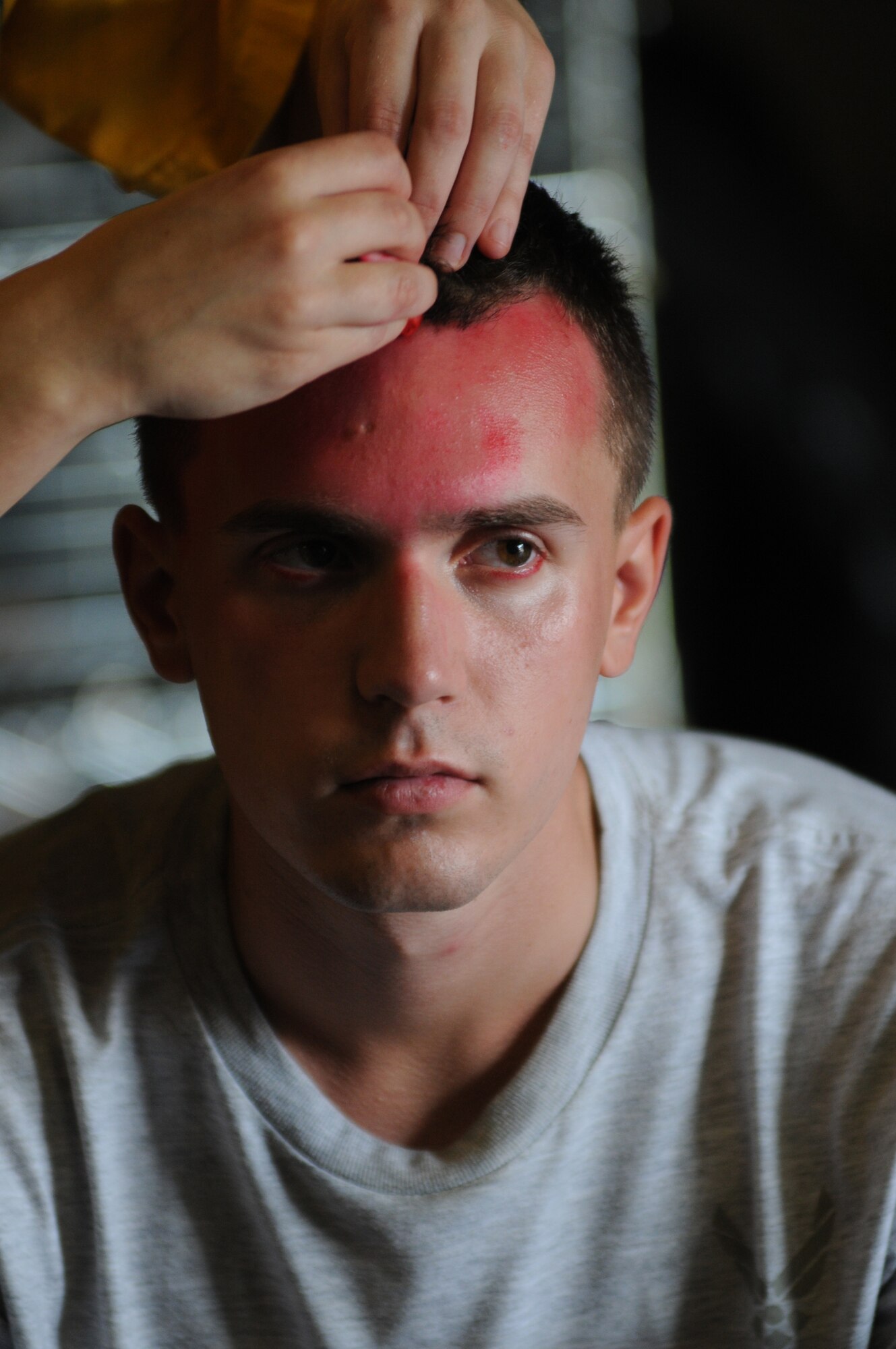 Airman Basic Malachi Rizzo, 336th Training Squadron, has moulage applied to his face for a more realistic effect during an exercise July 18, 2012, at Keesler Air Force Base, Miss.  Keesler held the three-day exercise to test the response of base personnel. In the exercise scenario, a disgruntled base employee sprayed harmful chemicals on Airmen in the Triangle training area injuring several people. Witnesses contacted 911 and within minutes, members of the 81st Security Forces Squadron apprehended the individual and first responders began decontamination and treatment of the victims. (U.S. Air Force photo by Kemberly Groue)