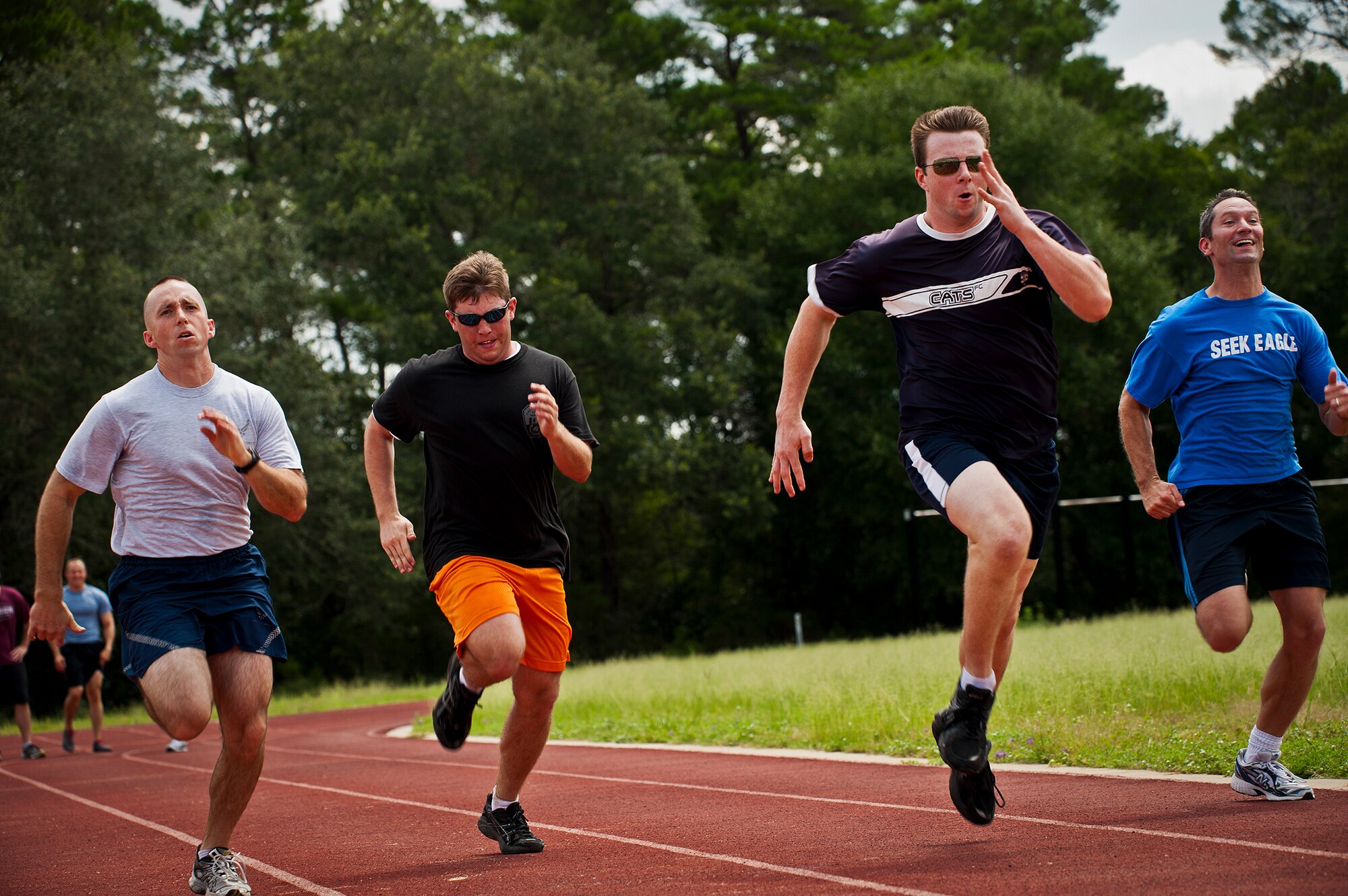 1st Lt. Heath Honaker, 2nd Lt. Tom Pace, Flt. Lt. David Palmer, and James Clifton sprint toward the finish in the 100-meter dash during the Air Force Seek Eagle’s Olympics July 19 at Eglin Air Force Base, Fla.  The SE office’s personnel participated in various sports events before a gold medal presentation and shrimp boil.  (U.S. Air Force photo/Samuel King Jr.)