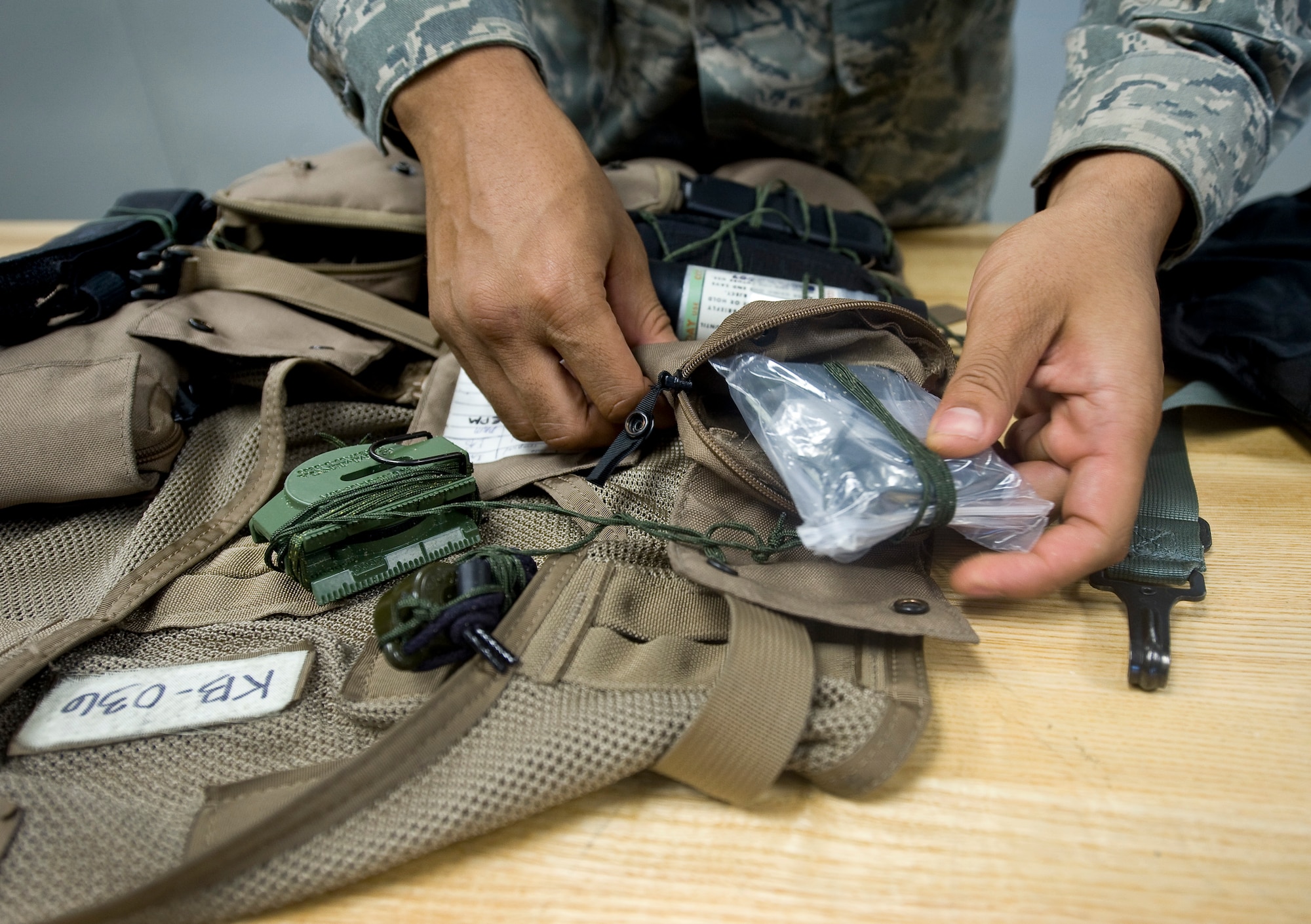 Airman Delonte Vance, 2nd Operations Support Squadron aircrew flight equipment journeyman, takes inventory of a survival vest during a yearly inspection at Barksdale Air Force Base, La., July 19. The survival vests are equipped with several tools to assist crew members in the event of a crash. Included in the vest are signaling devices, water, fire starting equipment and navigation aids. (U.S. Air Force photo/Staff Sgt. Chad Warren)(RELEASED)