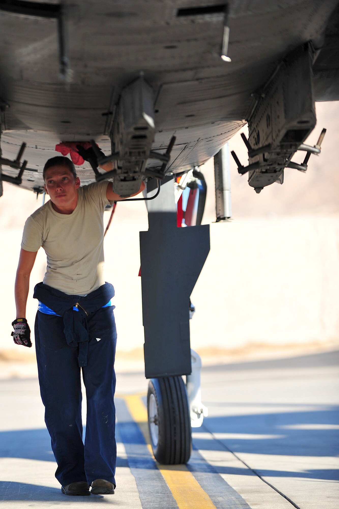 U.S. Air Force Airman 1st Class Grace Wheeler, a crew chief with the 23d Aircraft Maintenance Squadron, 74th Aircraft Maintenance Unit, checks the bottom of an A-10C Thunderbolt II for leaks and cracks during a post-flight inspection at Nellis Air Force Base, Nev., July 16,2012. The 23d AMXS/74th AMU is deployed to Nellis in support of the Red Flag 12-4 exercise, which runs July 16-27, 2012. Wheeler is one of two female crew chiefs in her unit participating in Red Flag and hopes to gain some more experience and training that will help her prepare for future deployments. (U.S. Air Force photo by Staff Sgt. Stephanie Mancha/Released) 